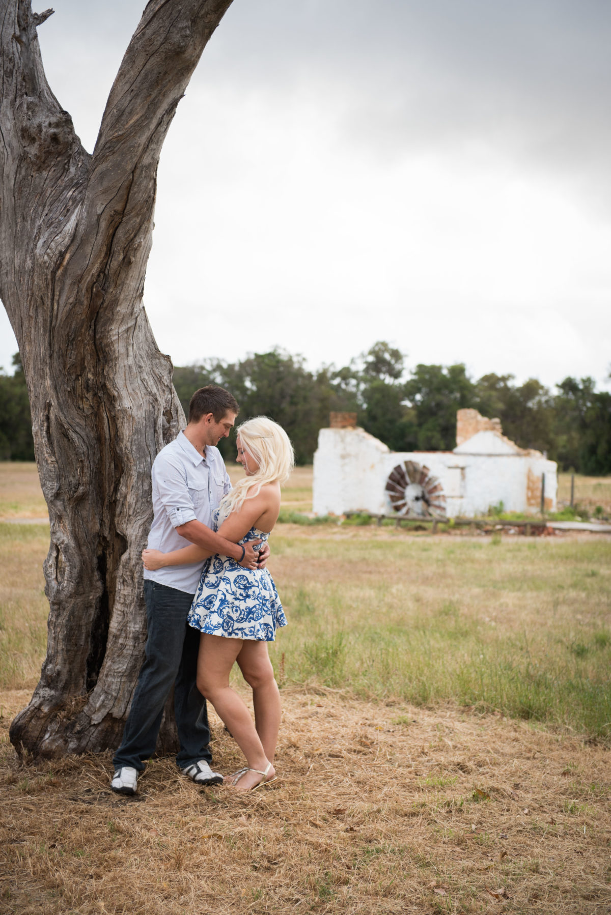 boy and girl hugging next to tree on engagement shoot