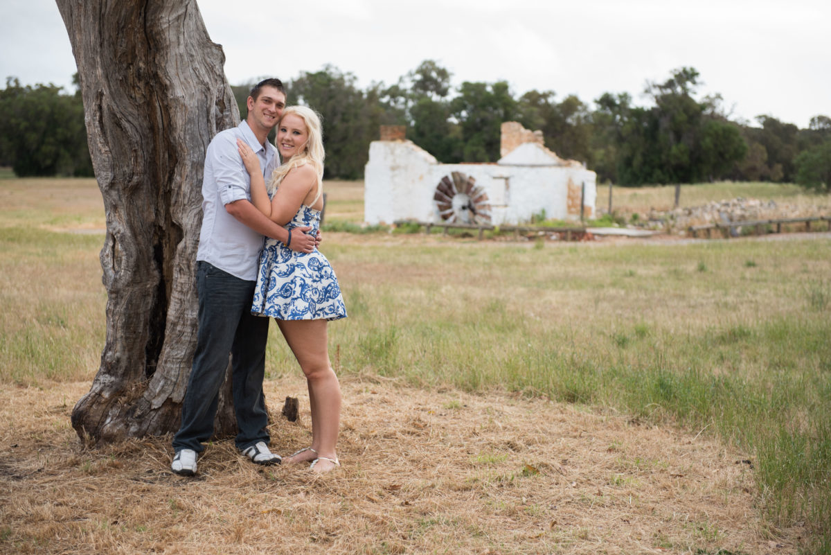 Engaged couple hugging next to tree at Perry's paddock