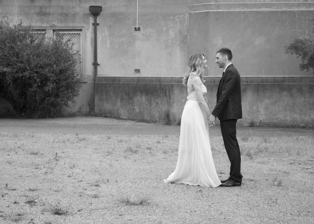 Black and white photo of bride and groom holding hands