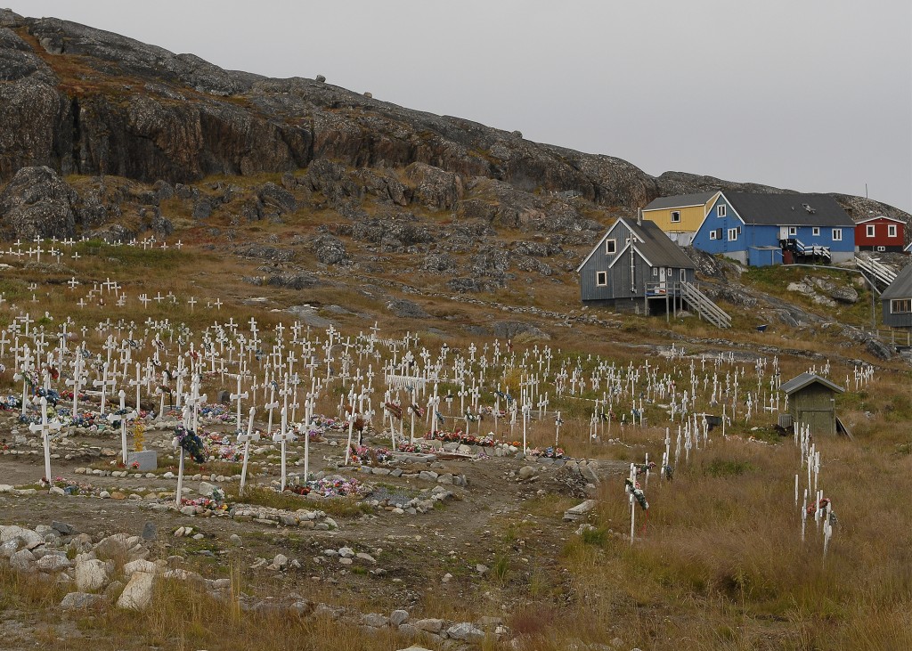 Cemetery in Qaqortoq, Greenland next to blue, yellow and red houses