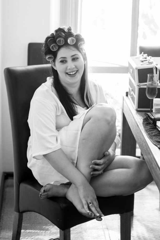 Bride getting ready for wedding. Curlers in her. Black and white photo