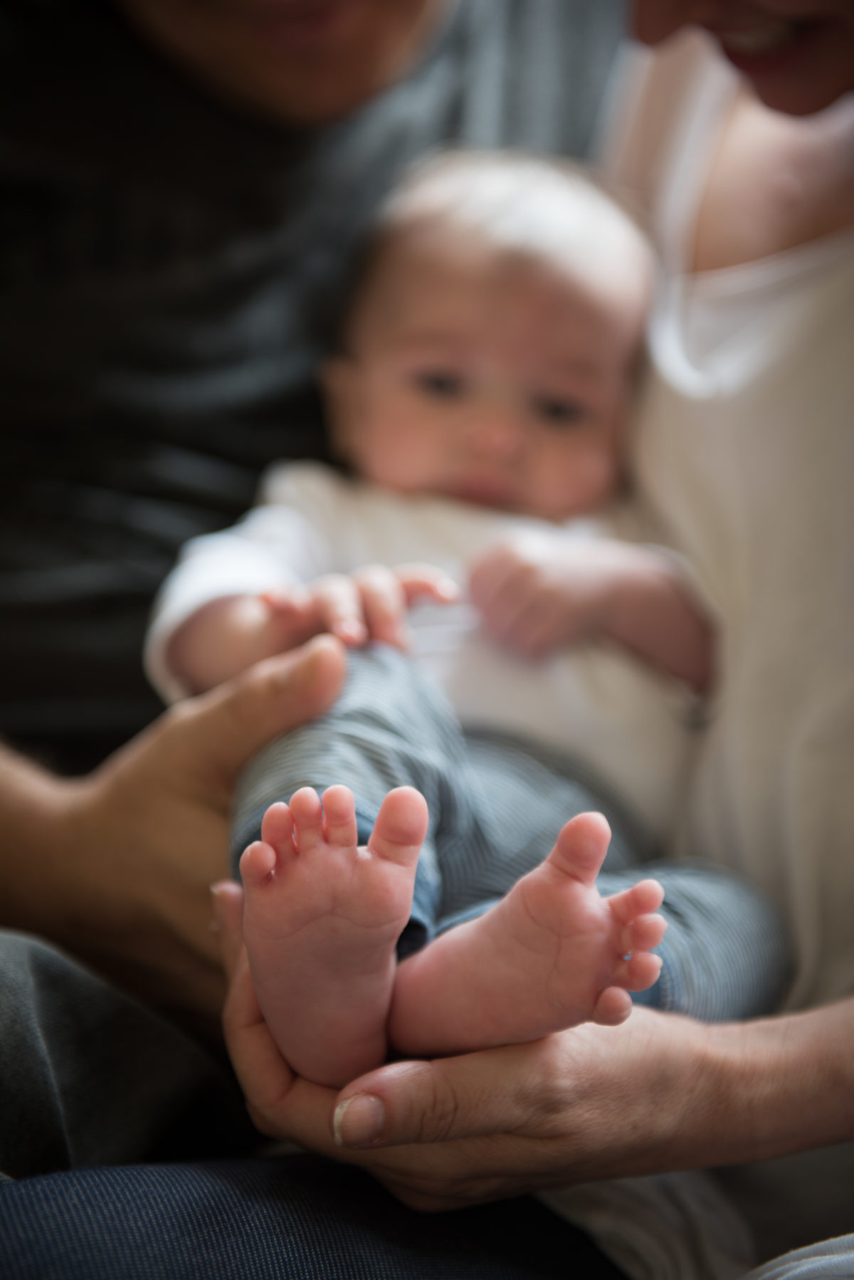 Close up of baby's feet being held by their parents