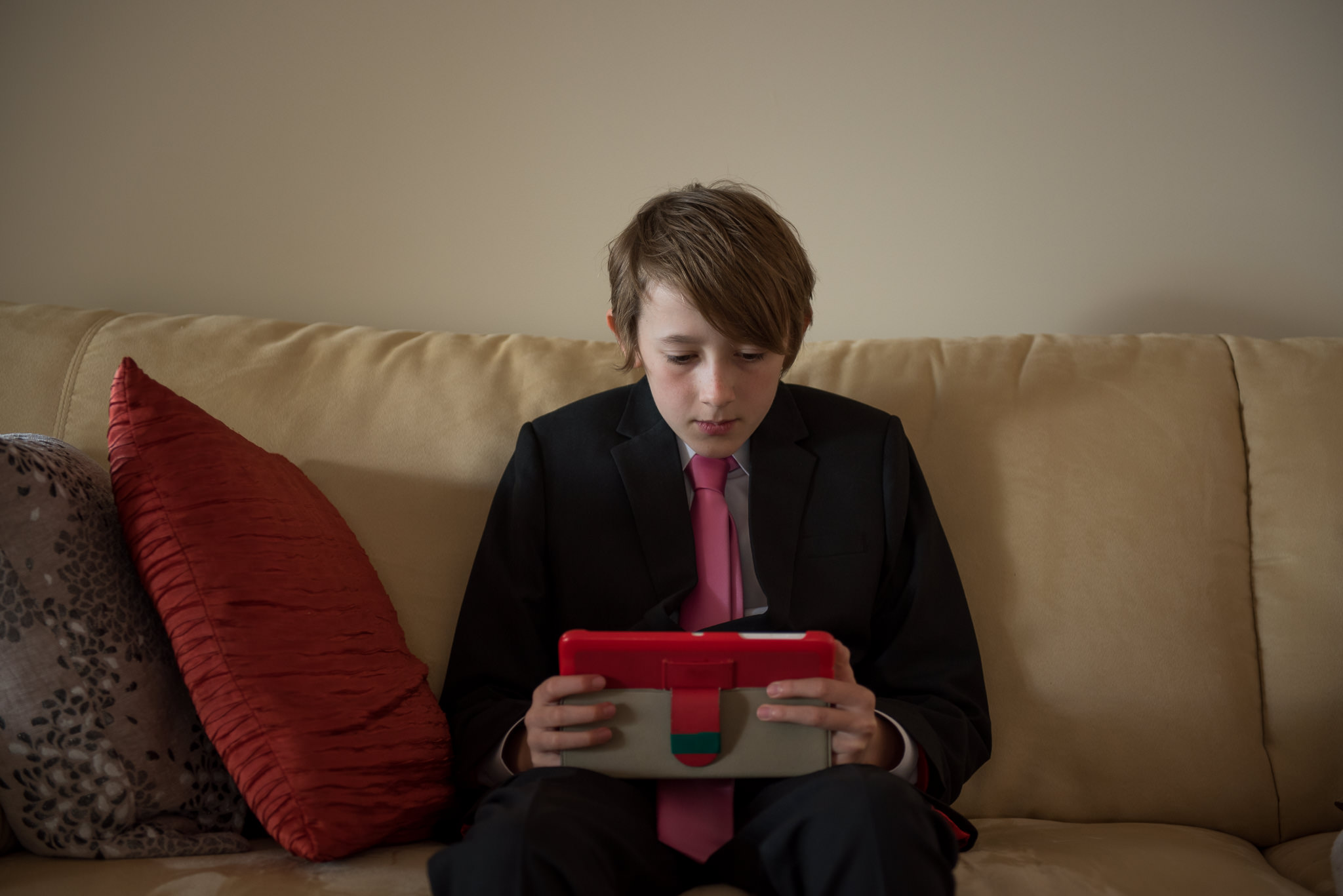 Page boy looking at his ipad on the lounge