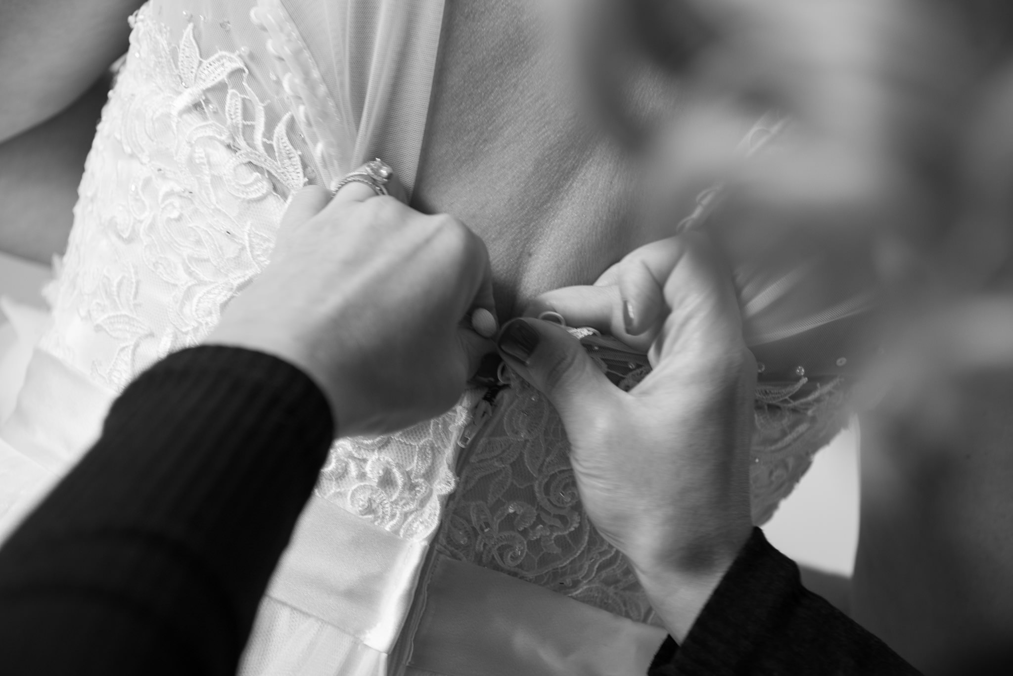 hands doing up the bride's wedding dress