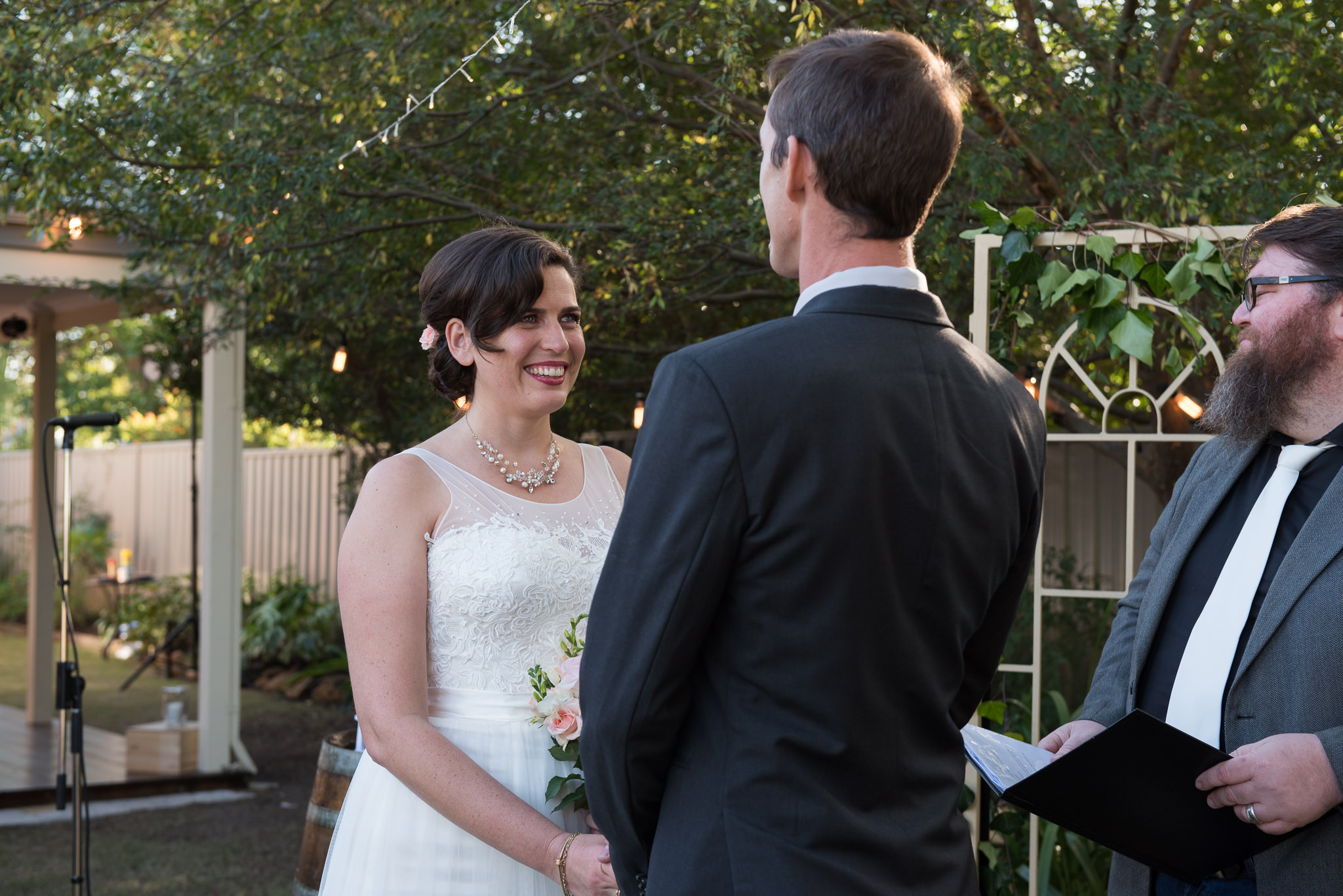 bride smiles at her groom in their backyard wedding