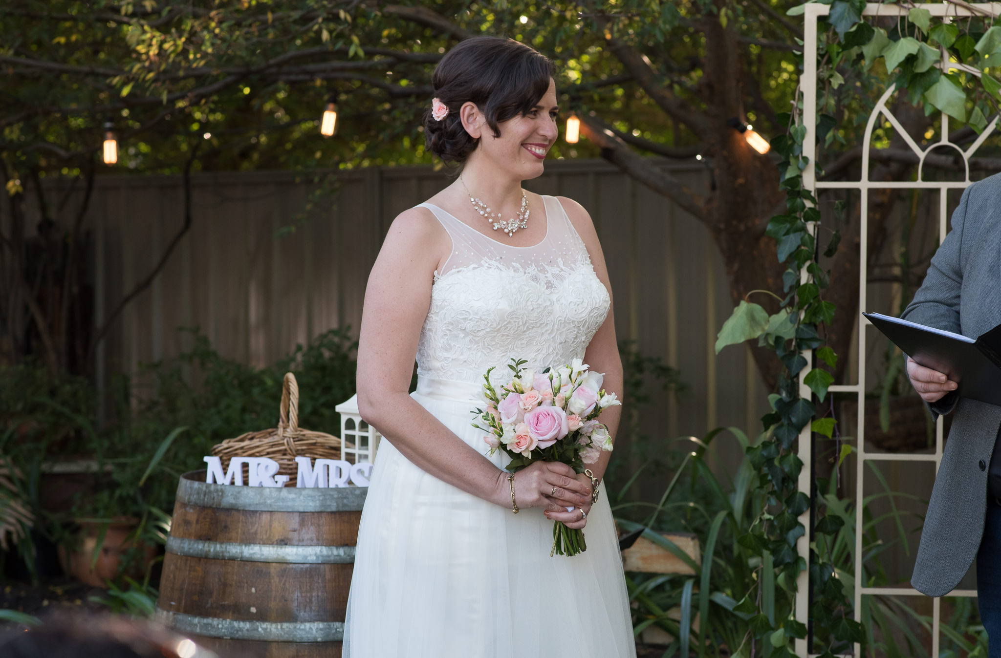 bride smiling holding her bouquet during her ceremony