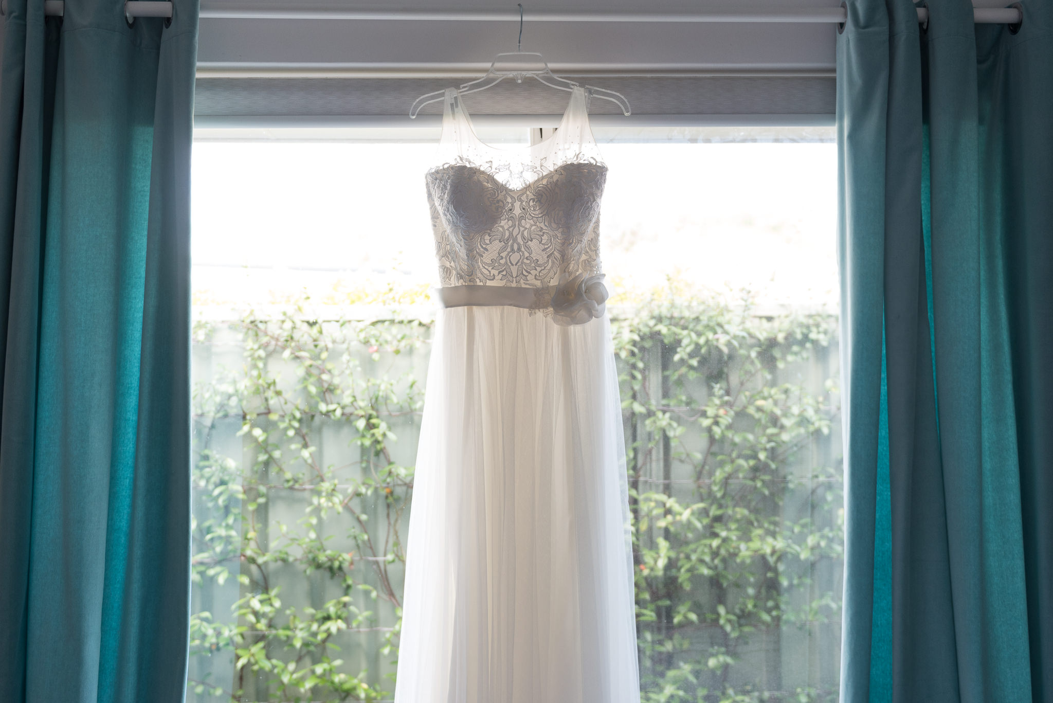 wedding dress hanging on a curtain rail