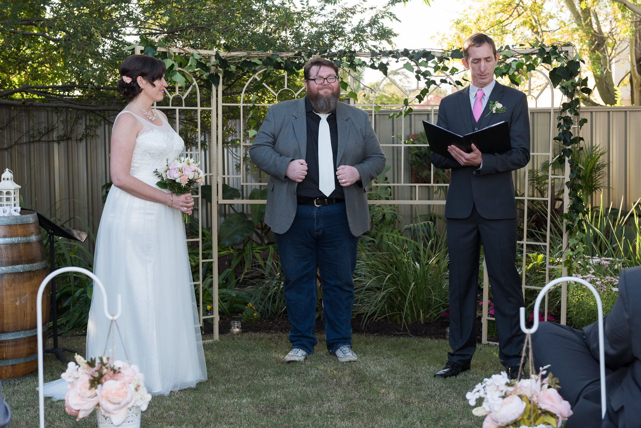 celebrant smiles while groom says his vows