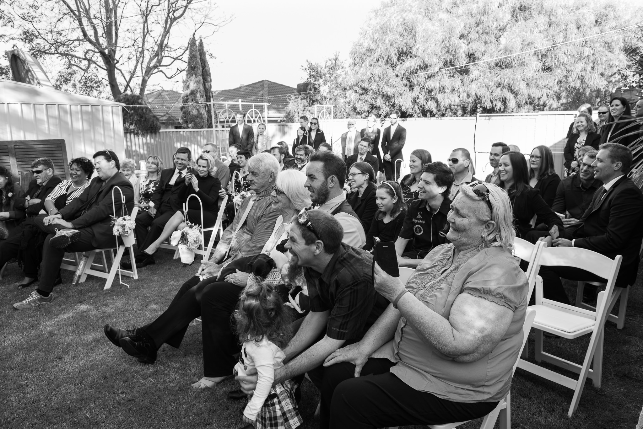 wedding guests looking on in backyard wedding in Manning