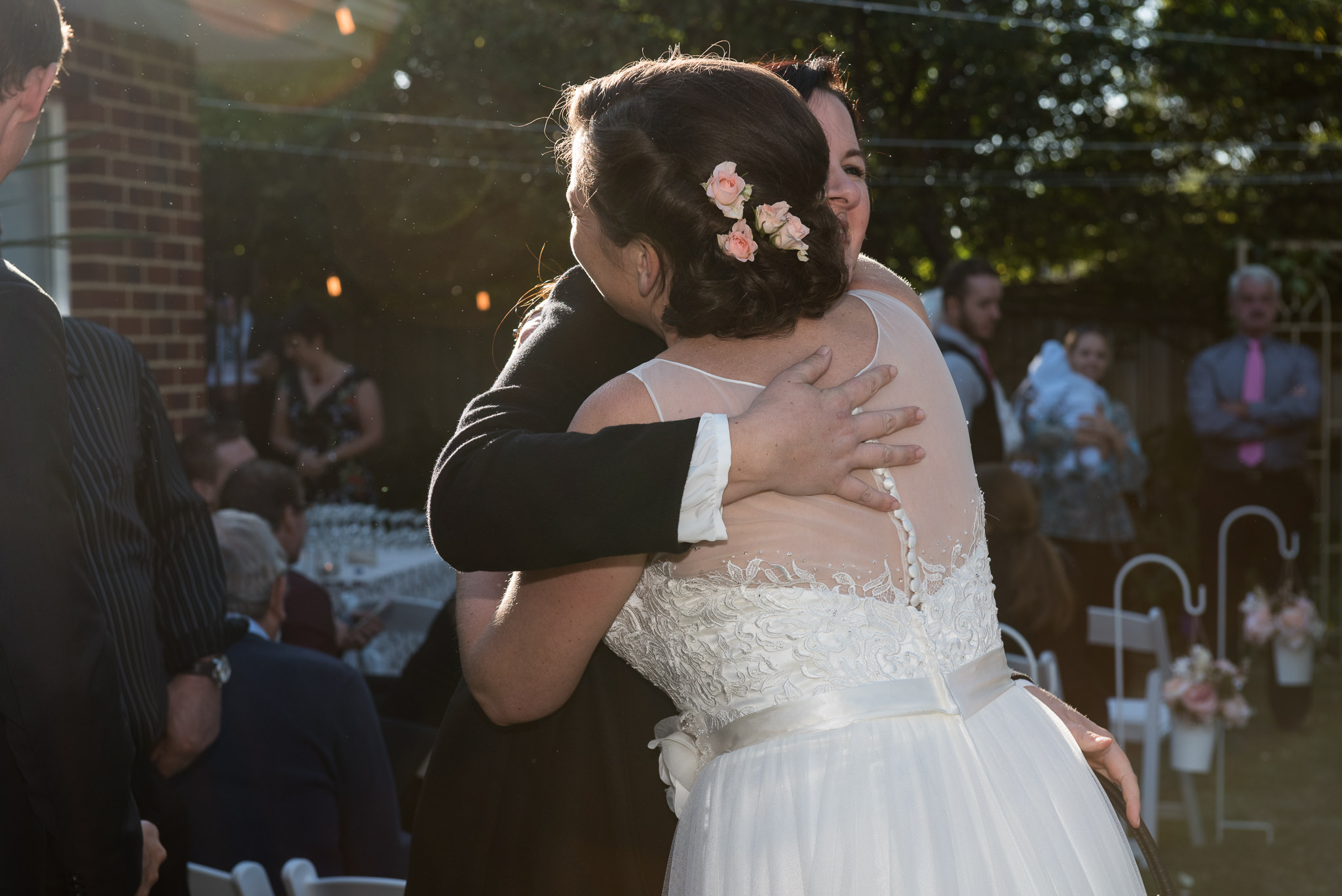 hugging the bride in the sun