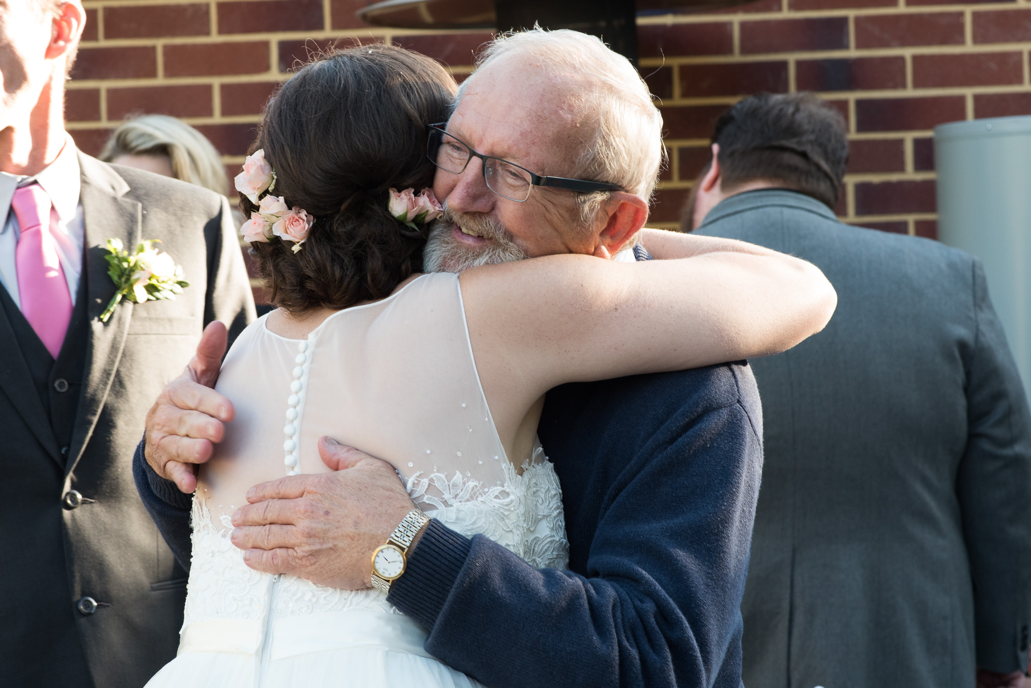 older wedding guests hugs bride