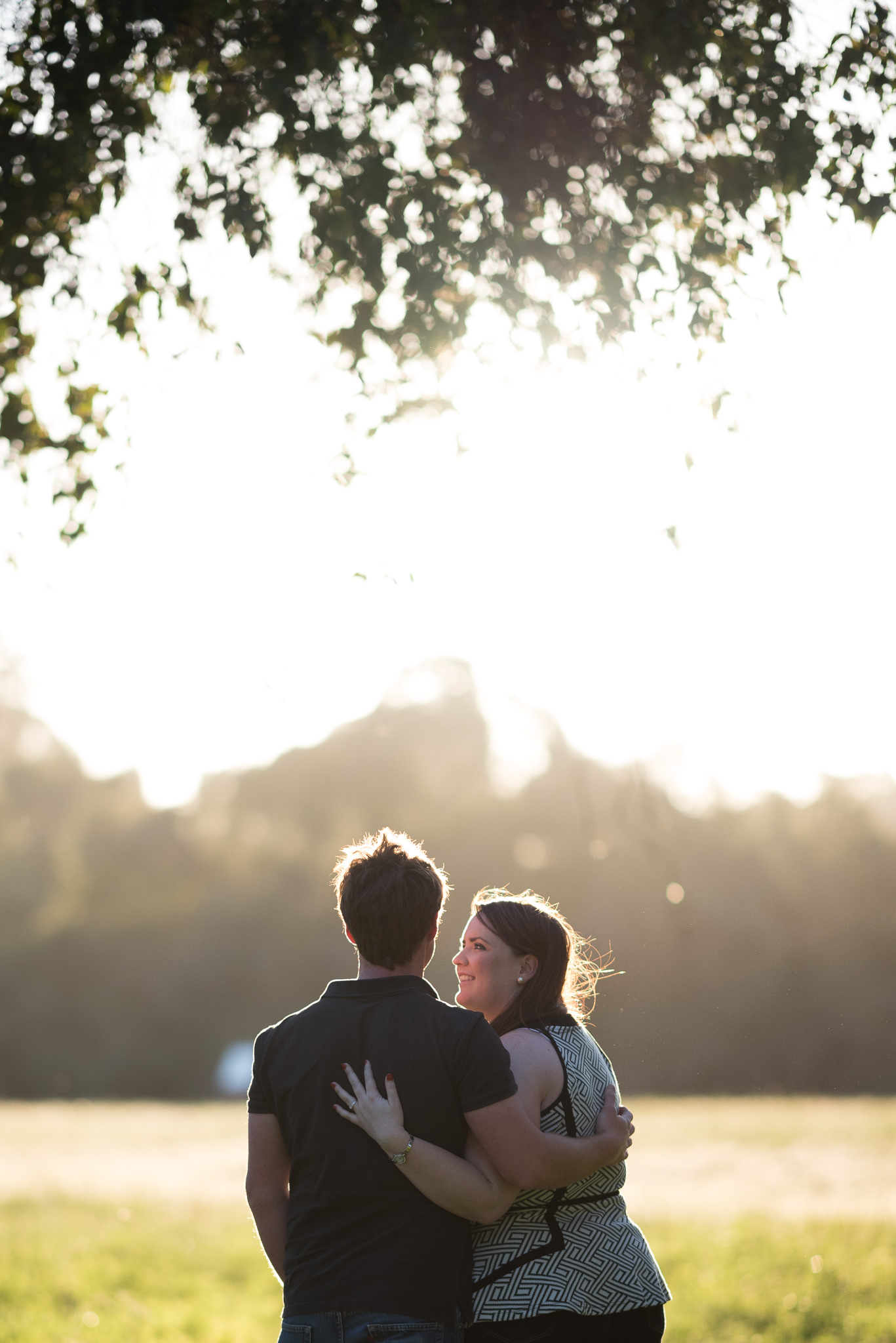 engaged couple rimmed by sunlight