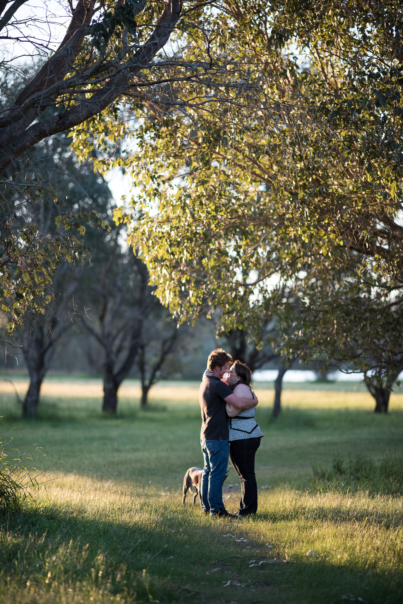 engaged couple are hugging at Yellagonga park