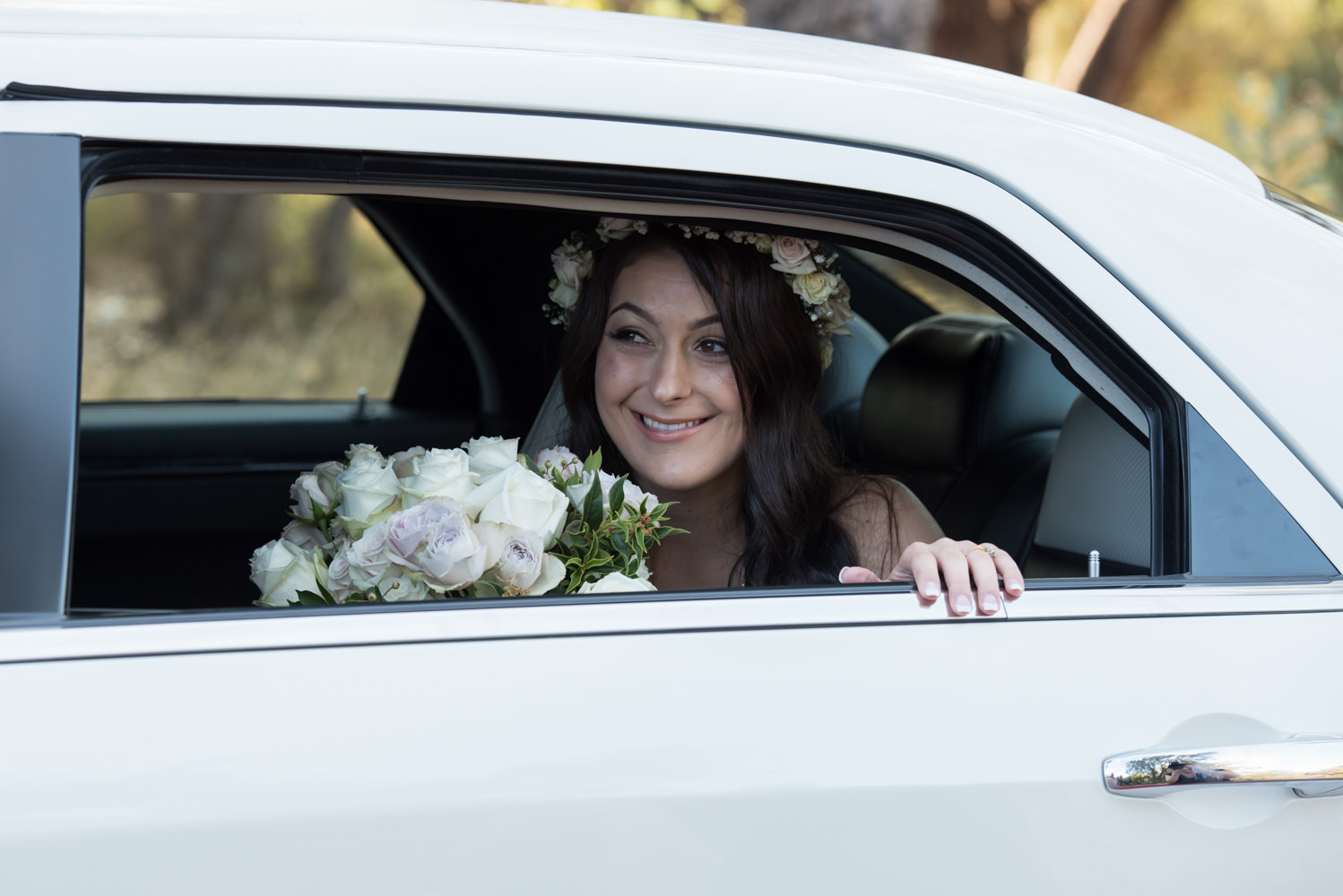 Bride arriving and smiling looking through the car window