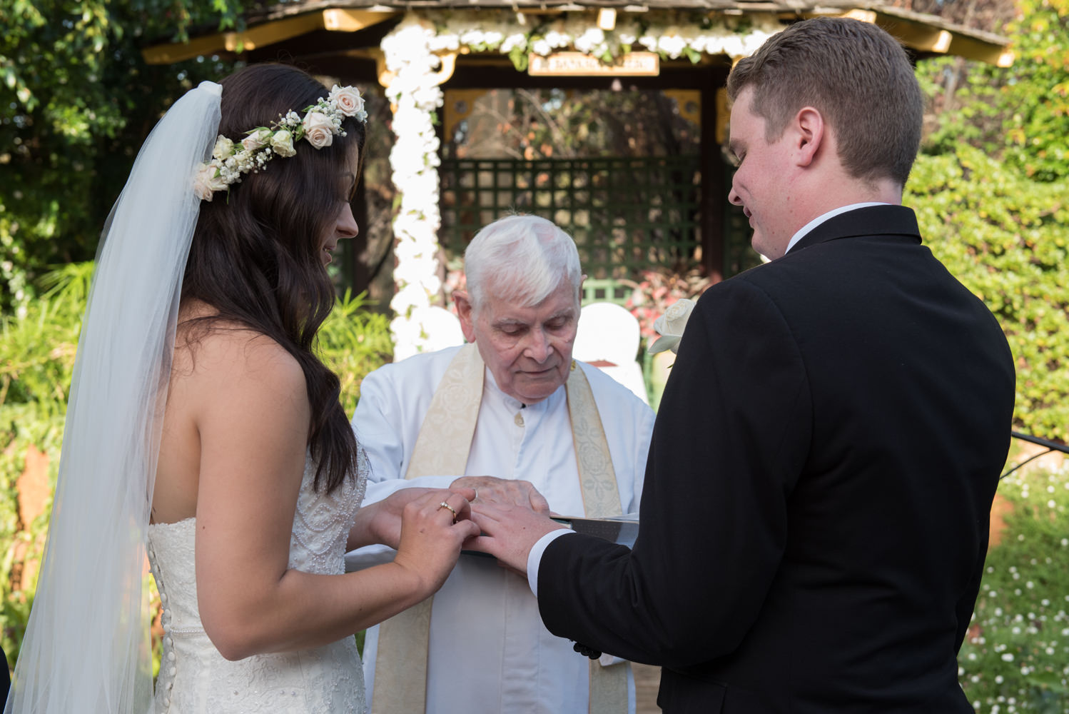 Bride putting ring on groom's finger