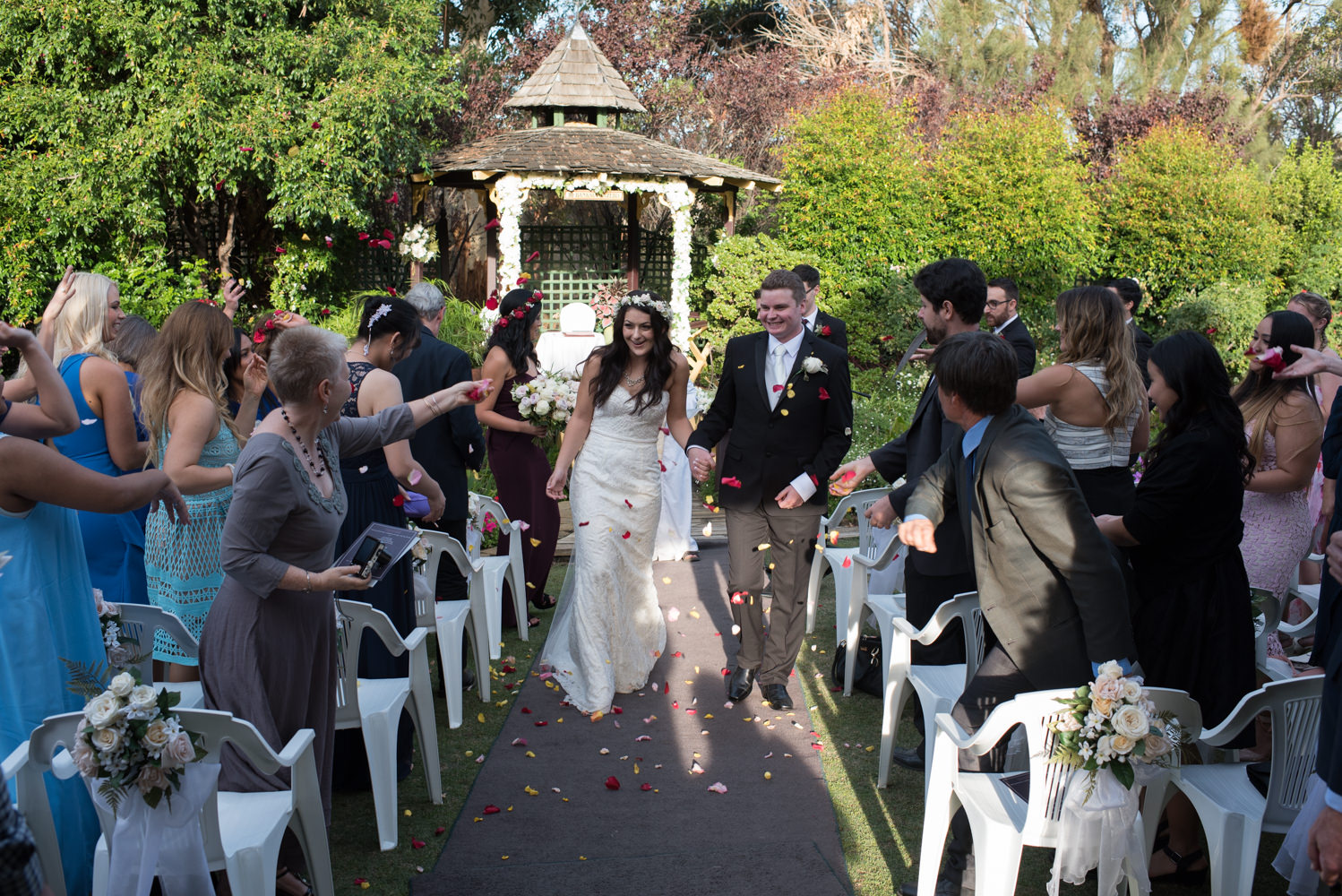 Rose petals being thrown over bride and groom