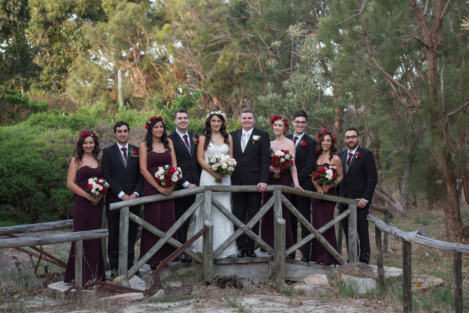 Bride and groom with bridal party on rustic bridge at Bridgeleigh reception centre