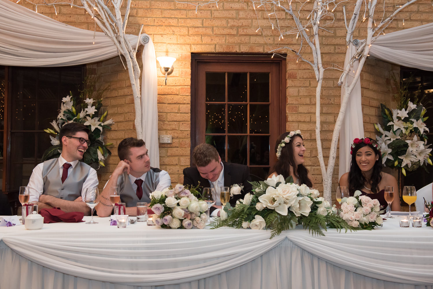 Bridal party laughing during wedding speeches