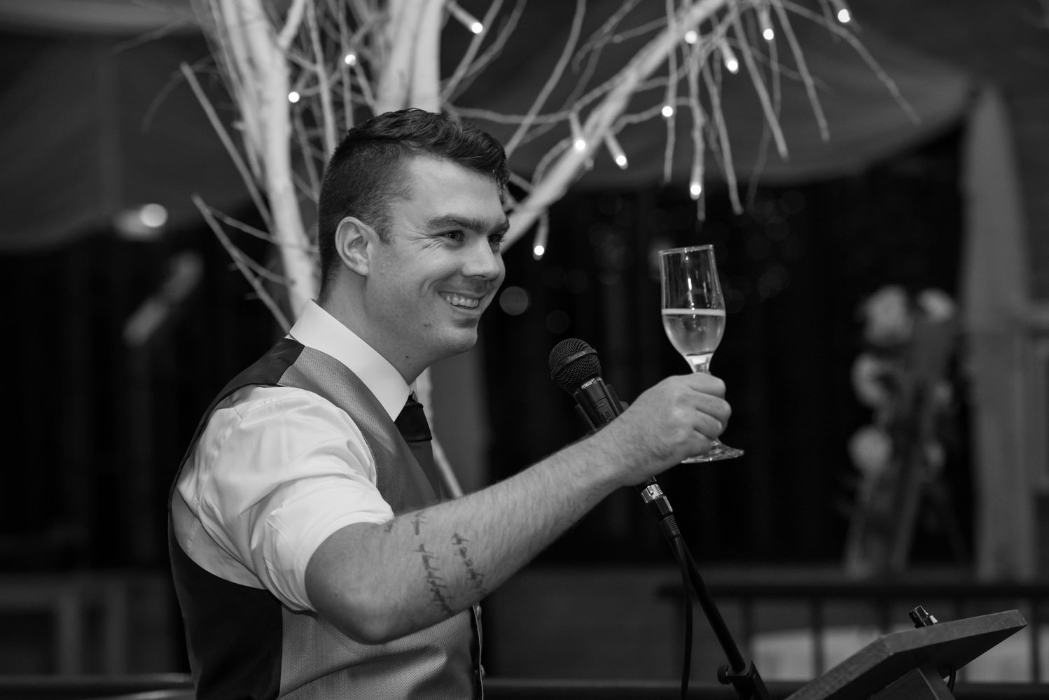 Best man raising his glass in a toast during his speech