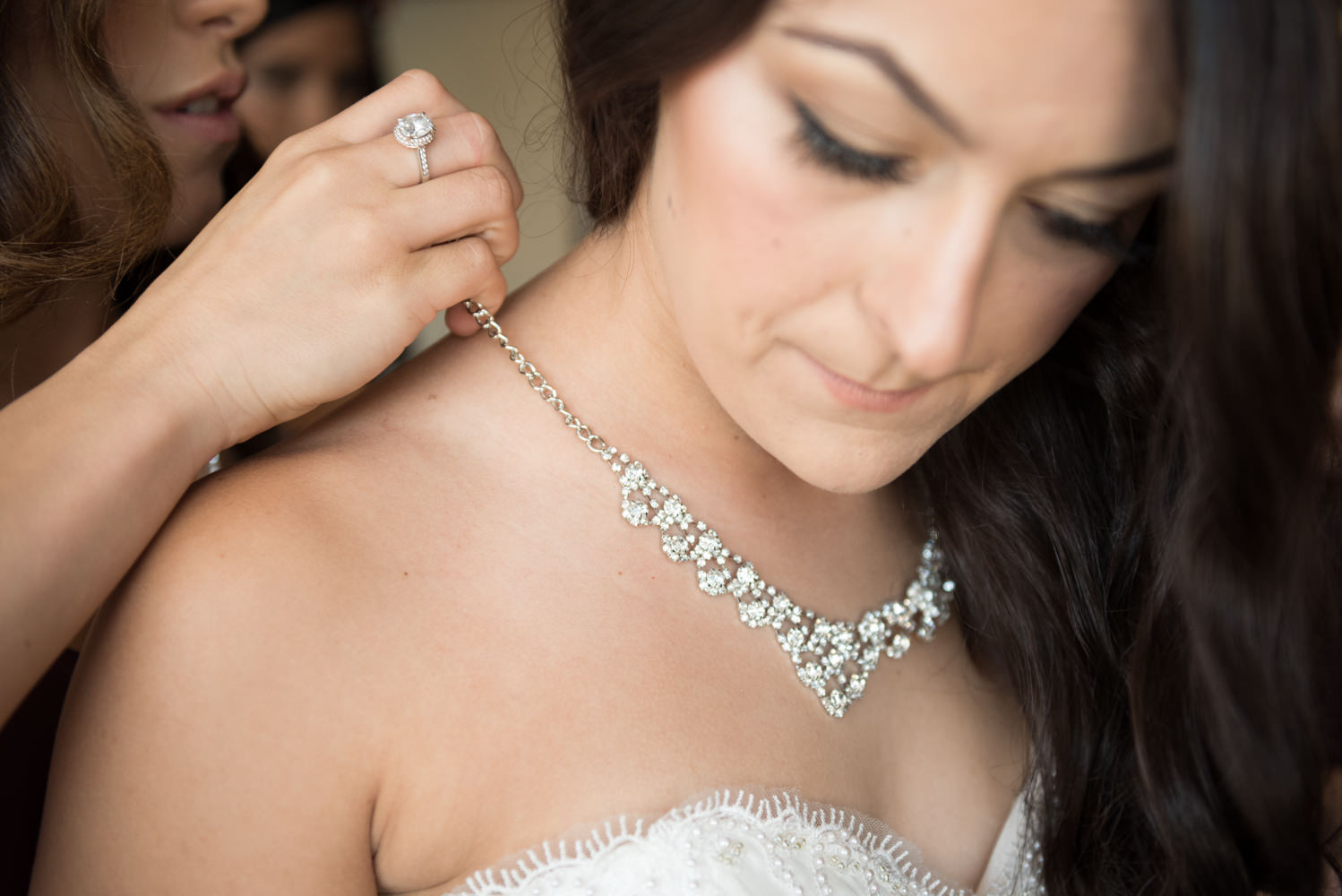 Bride having her necklace put on