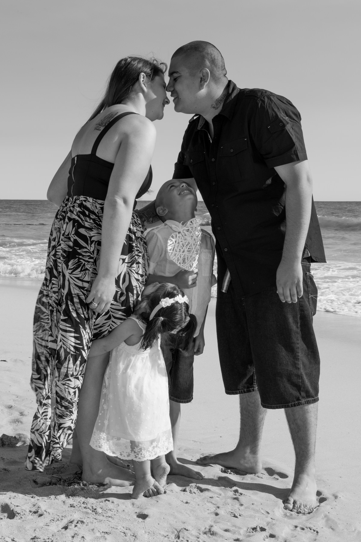 little boy looking up at his parents kissing