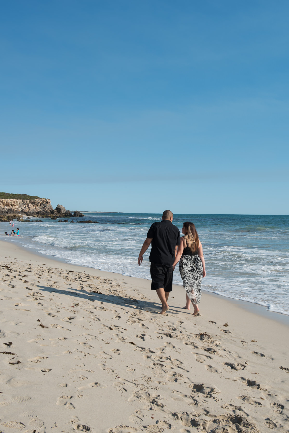 couple walking away on the beach