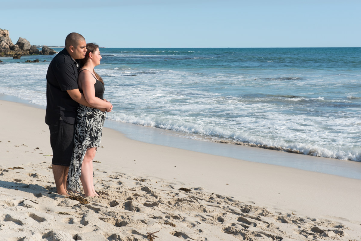 engaged couple overlooking the water