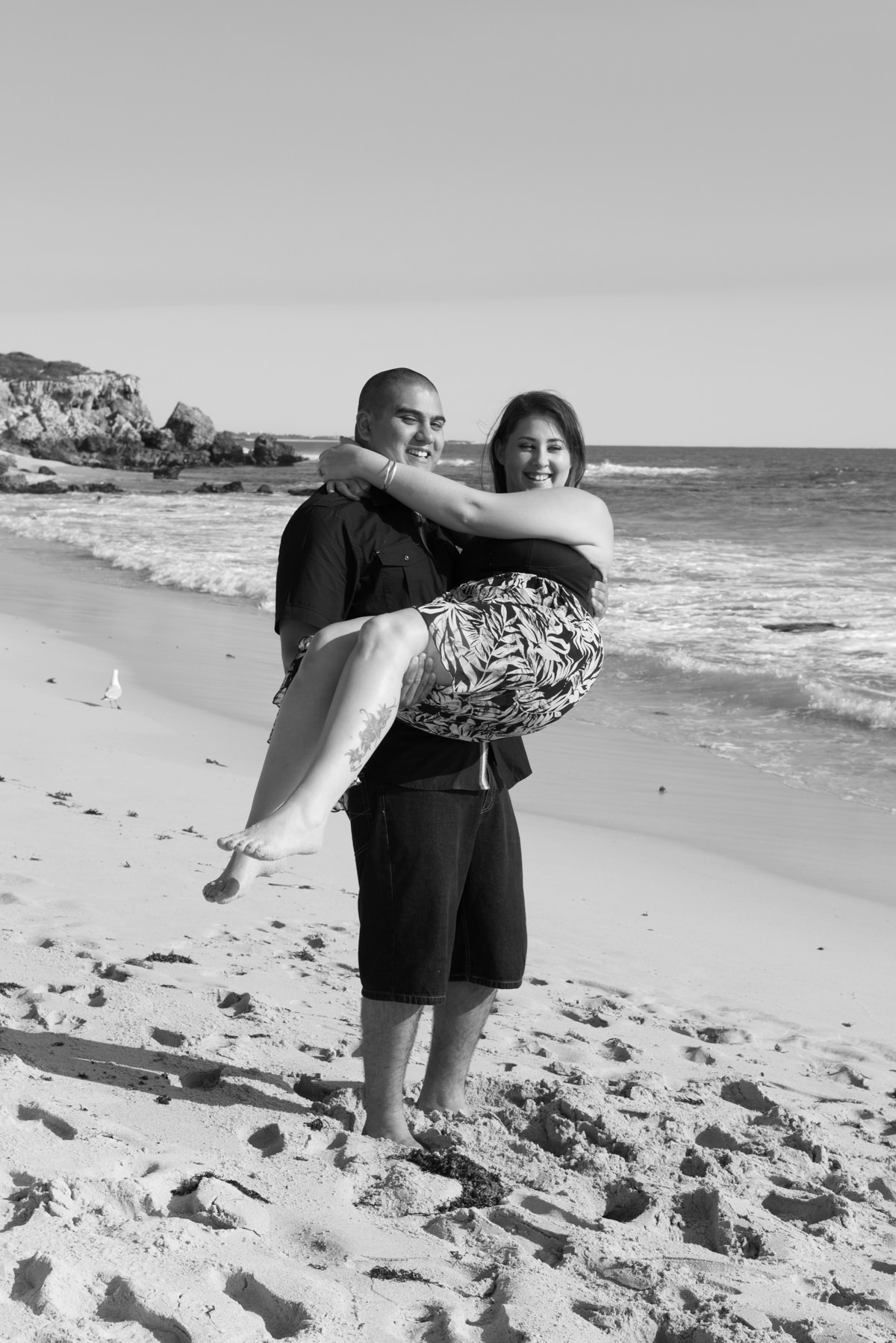 guy carries his fiance at Burns beach