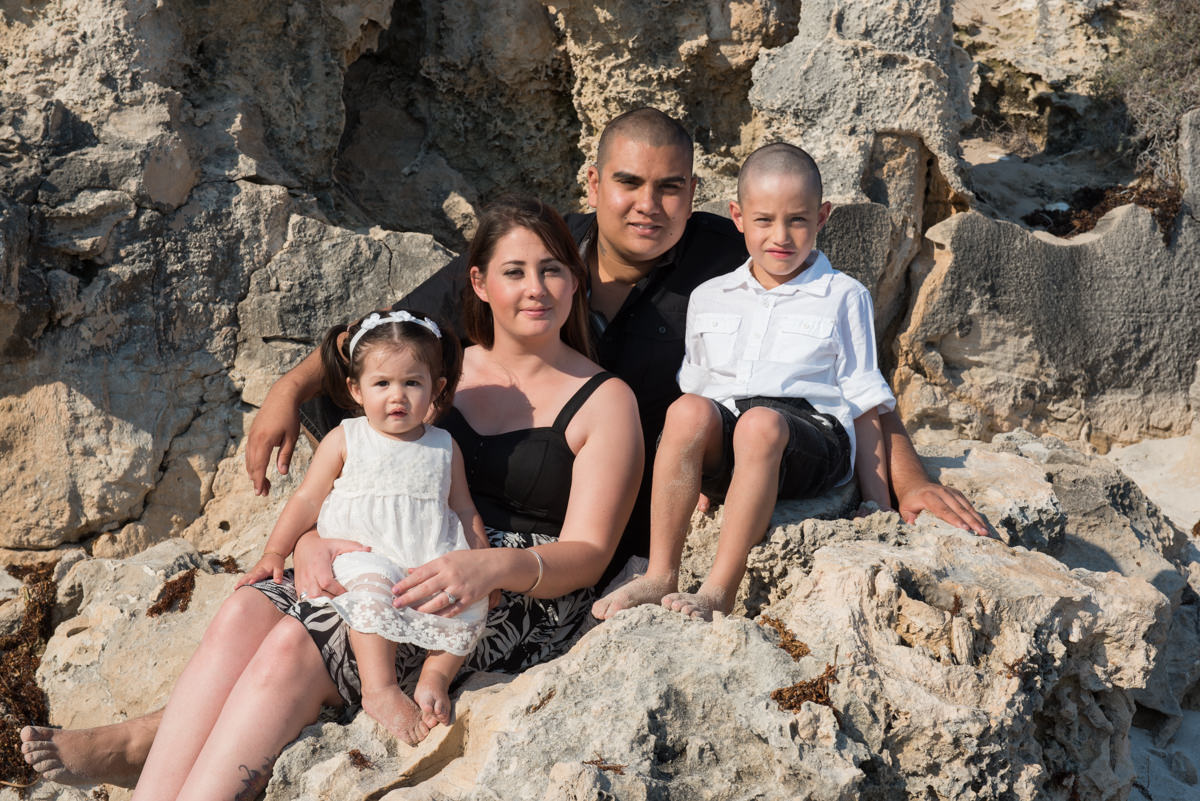 group photo sitting rocks at the beach