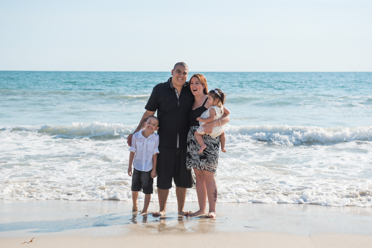 family cuddles in the surf shallows