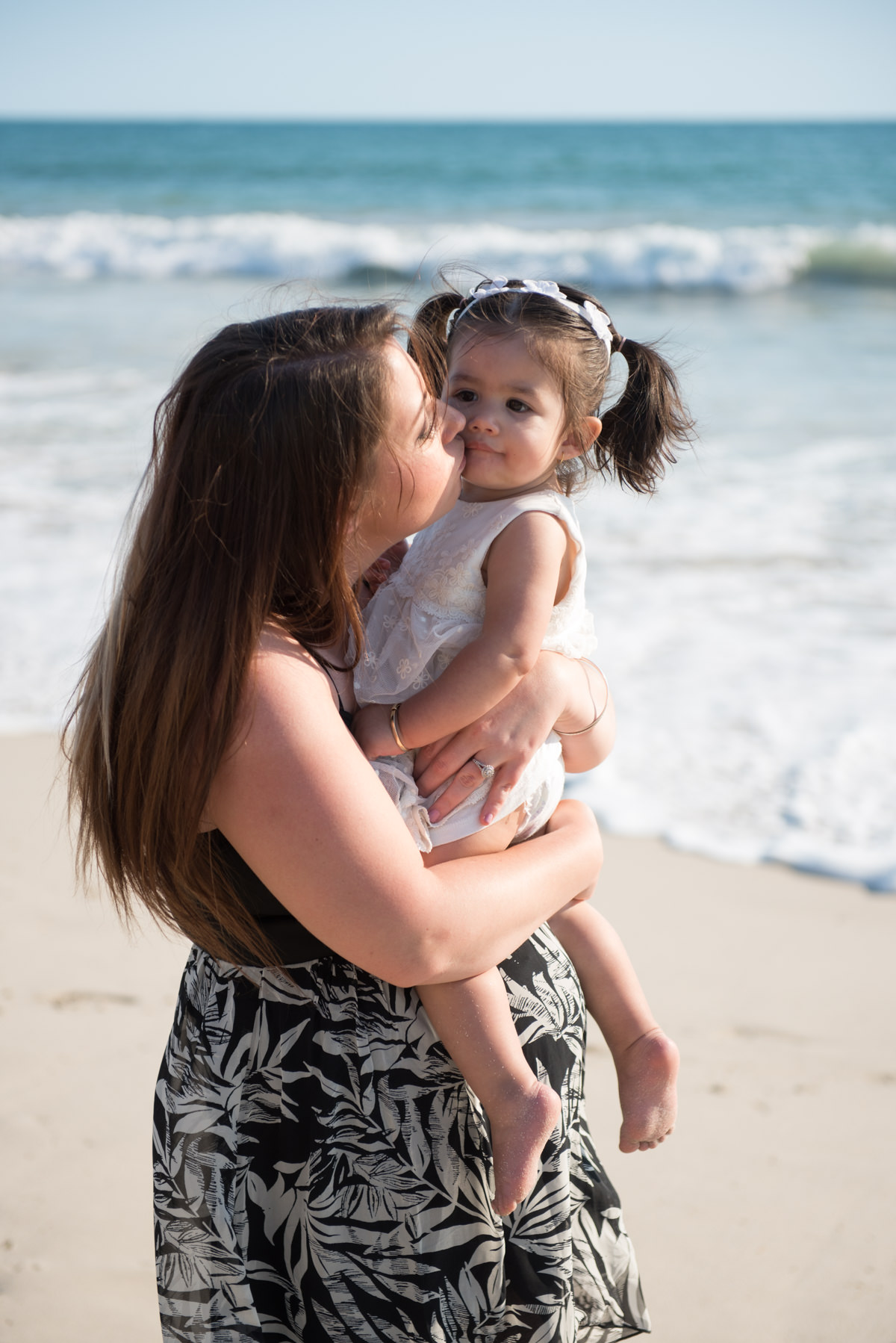 mother kissing her little daughter on the cheek