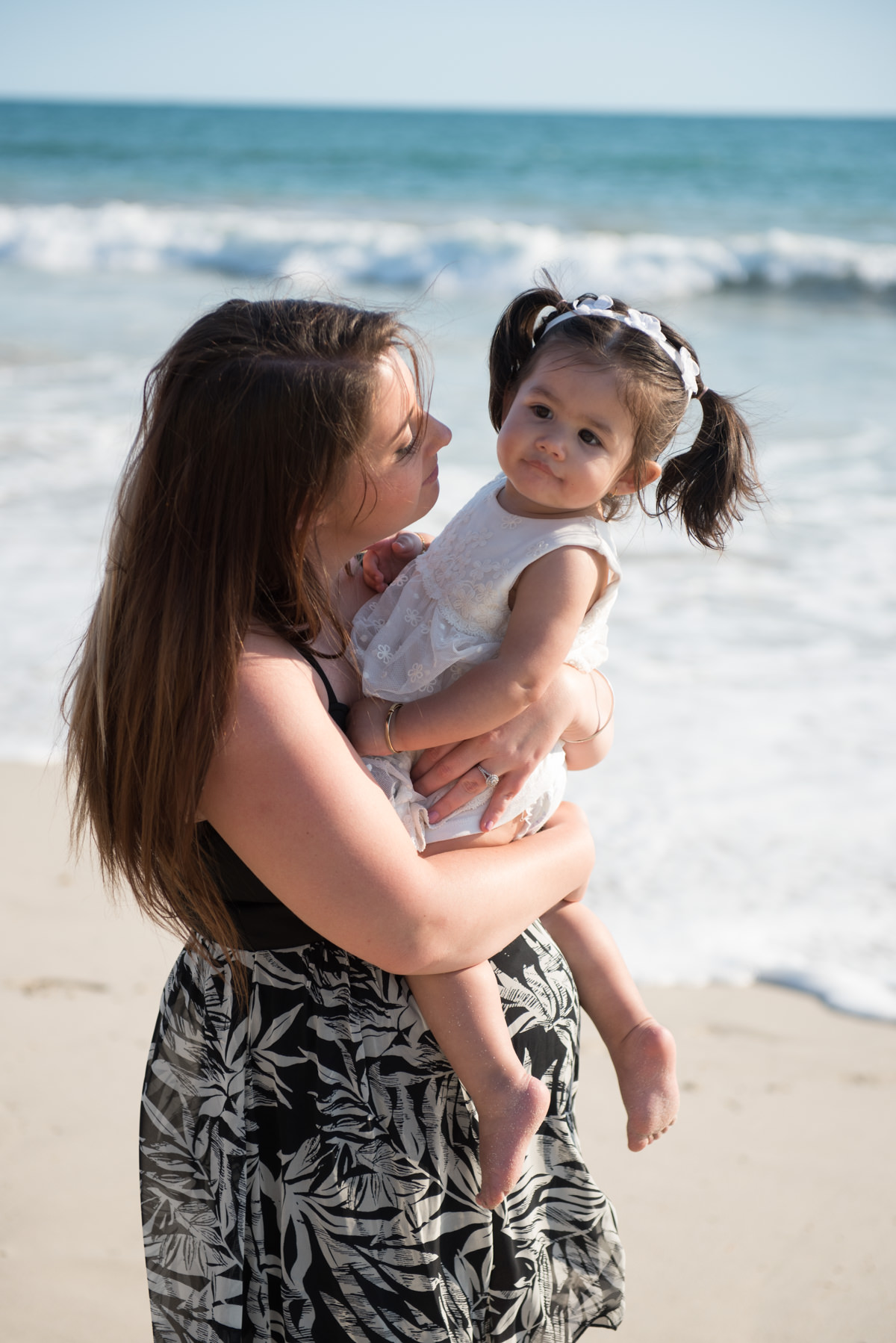 mother looking at her little daughter in pigtails