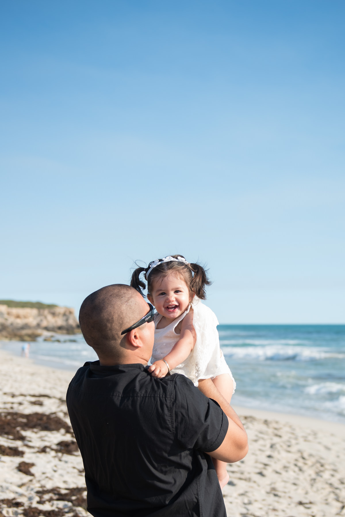 father picks up his daughter at the beach