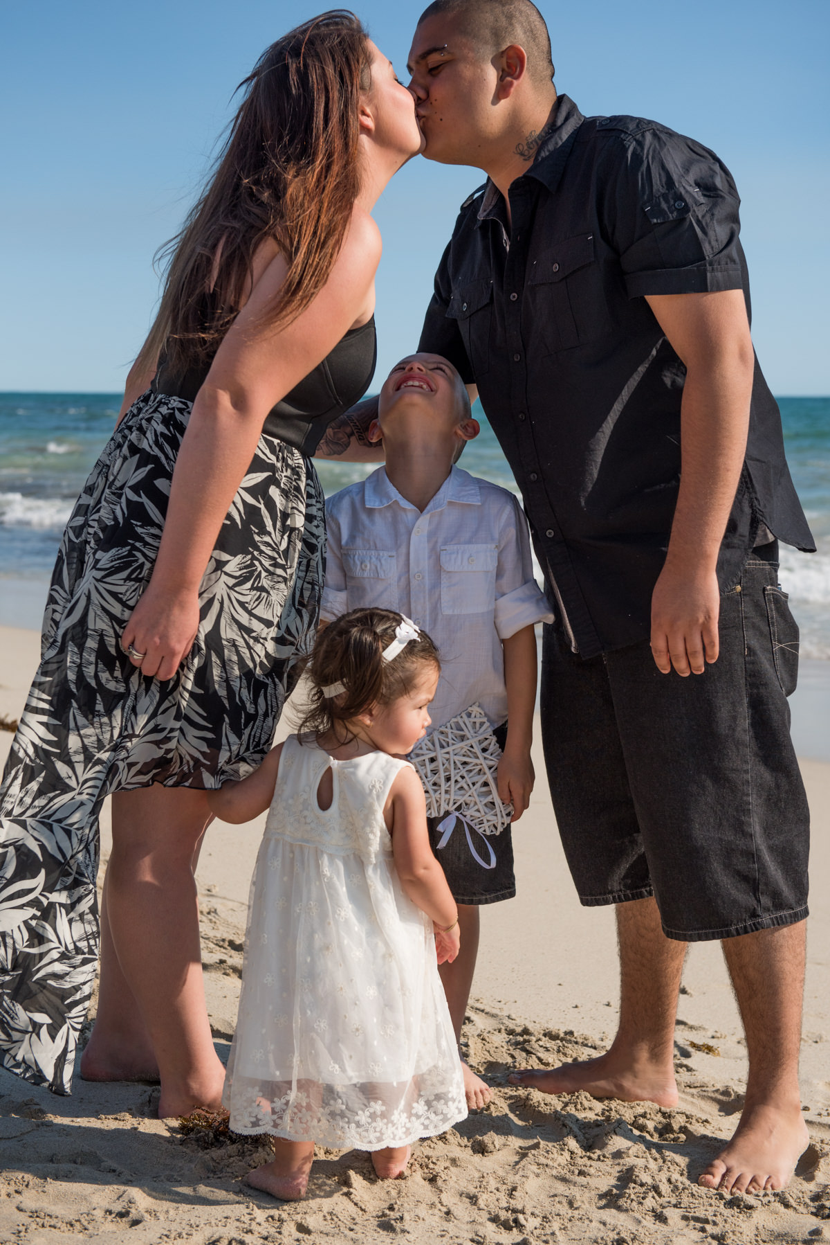 parents kiss on the beach