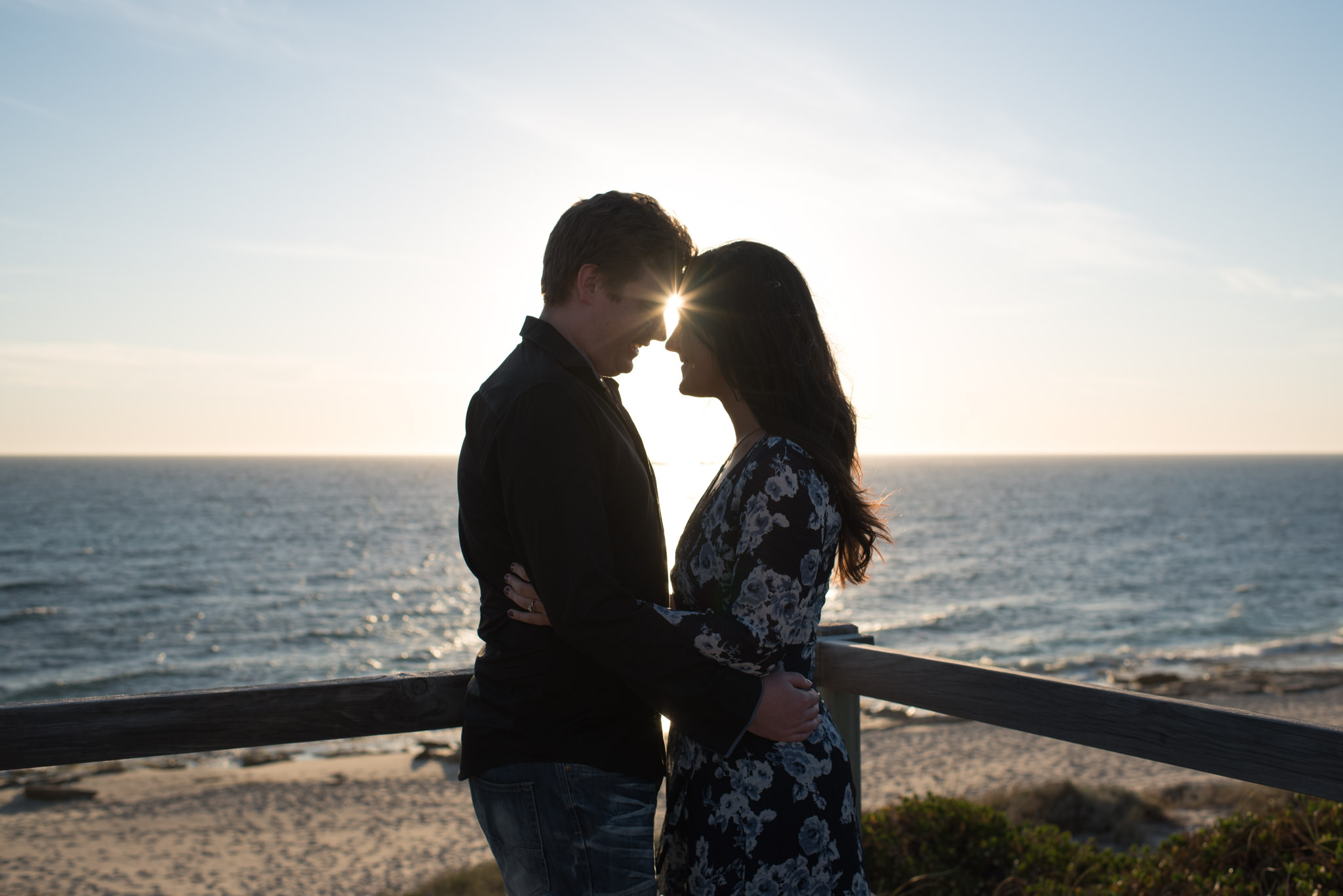 Starburst through couple's foreheads at the beach