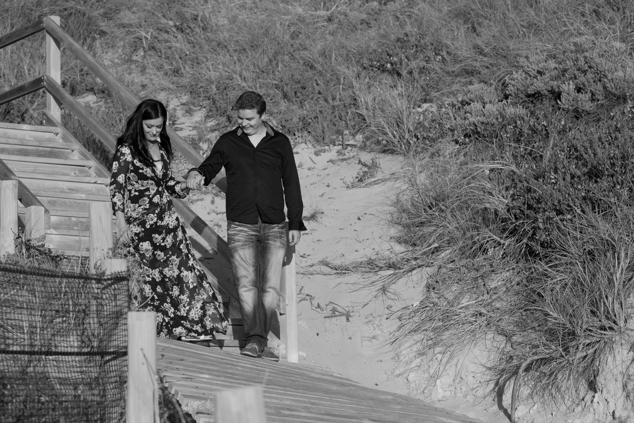 Boy helps girl down the steps at Burns beach