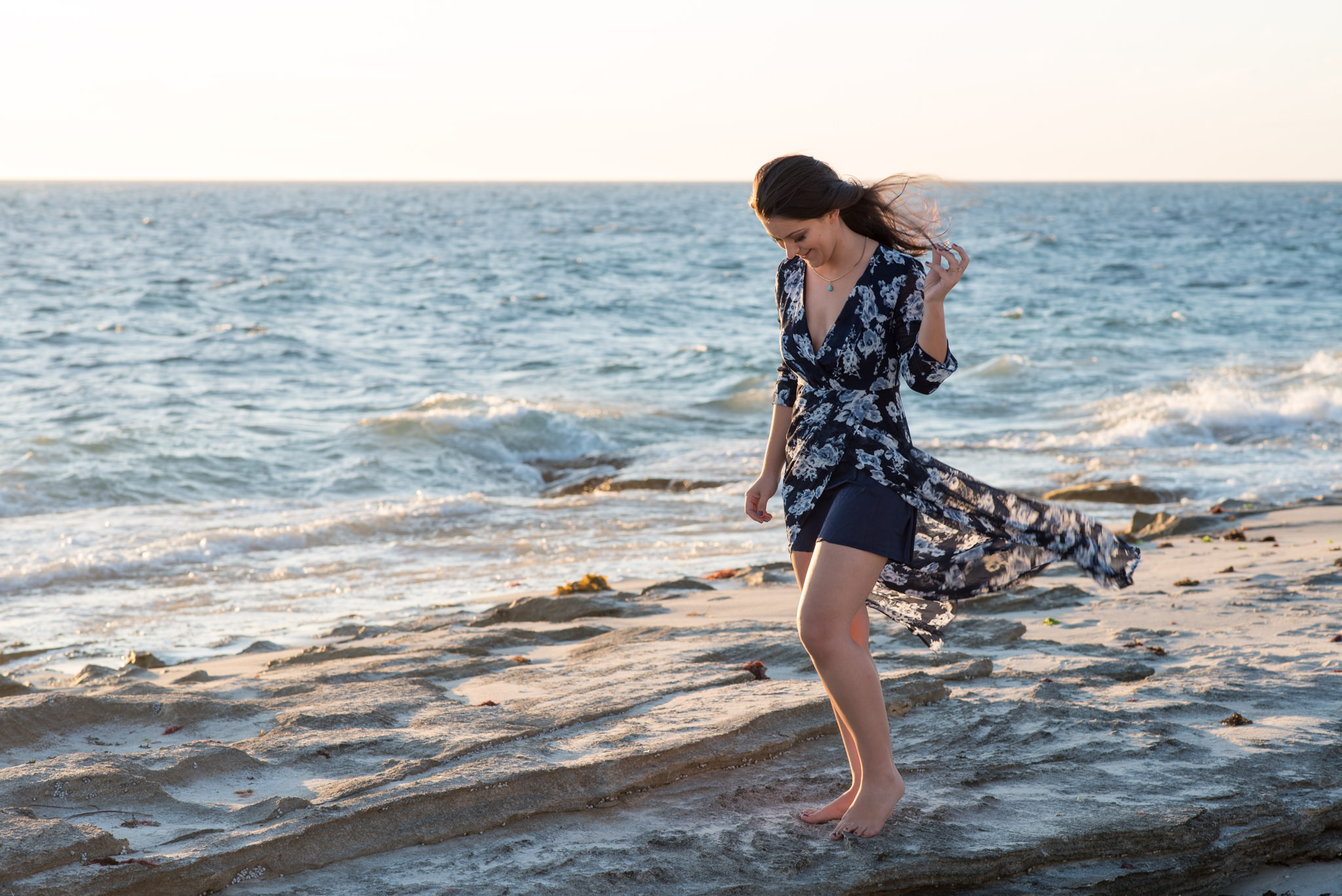 Girl standing on the rocks at the beach