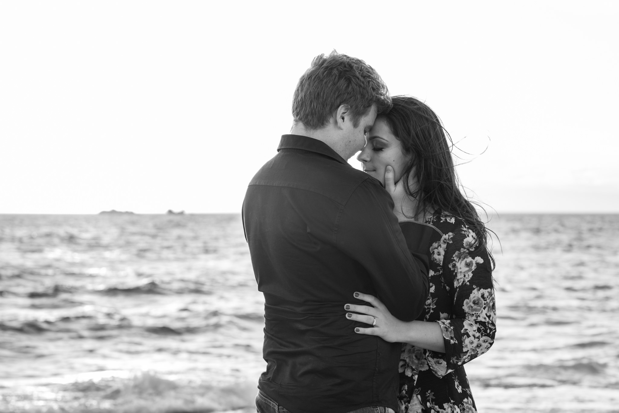 Boy and girl with foreheads together and eyes closed at the beach