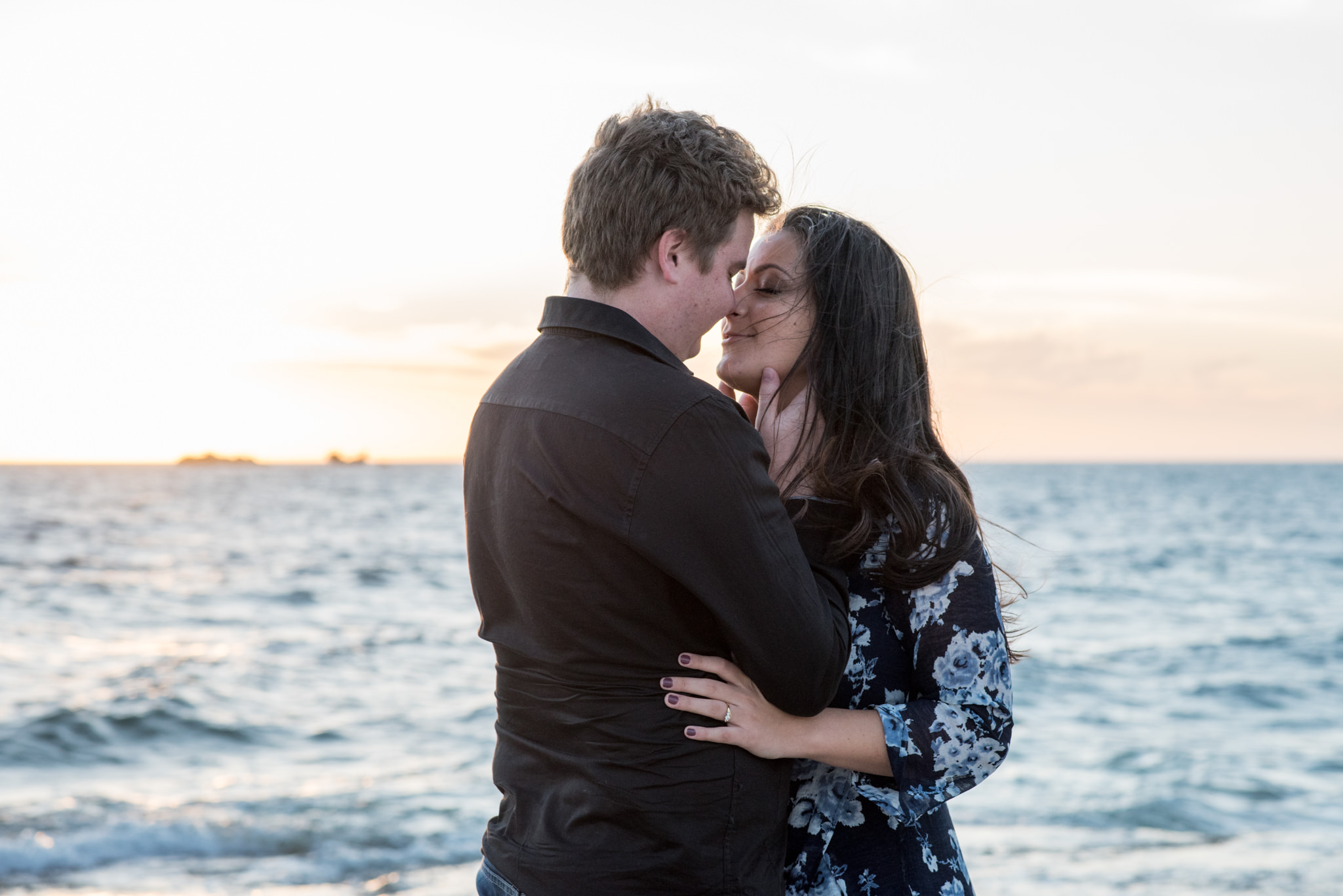 Boy and girl lean into each other for a kiss at the beach