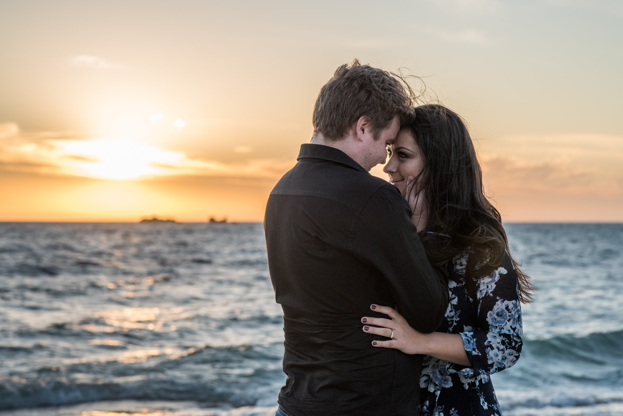 Boy and girl looking at each other with sun set