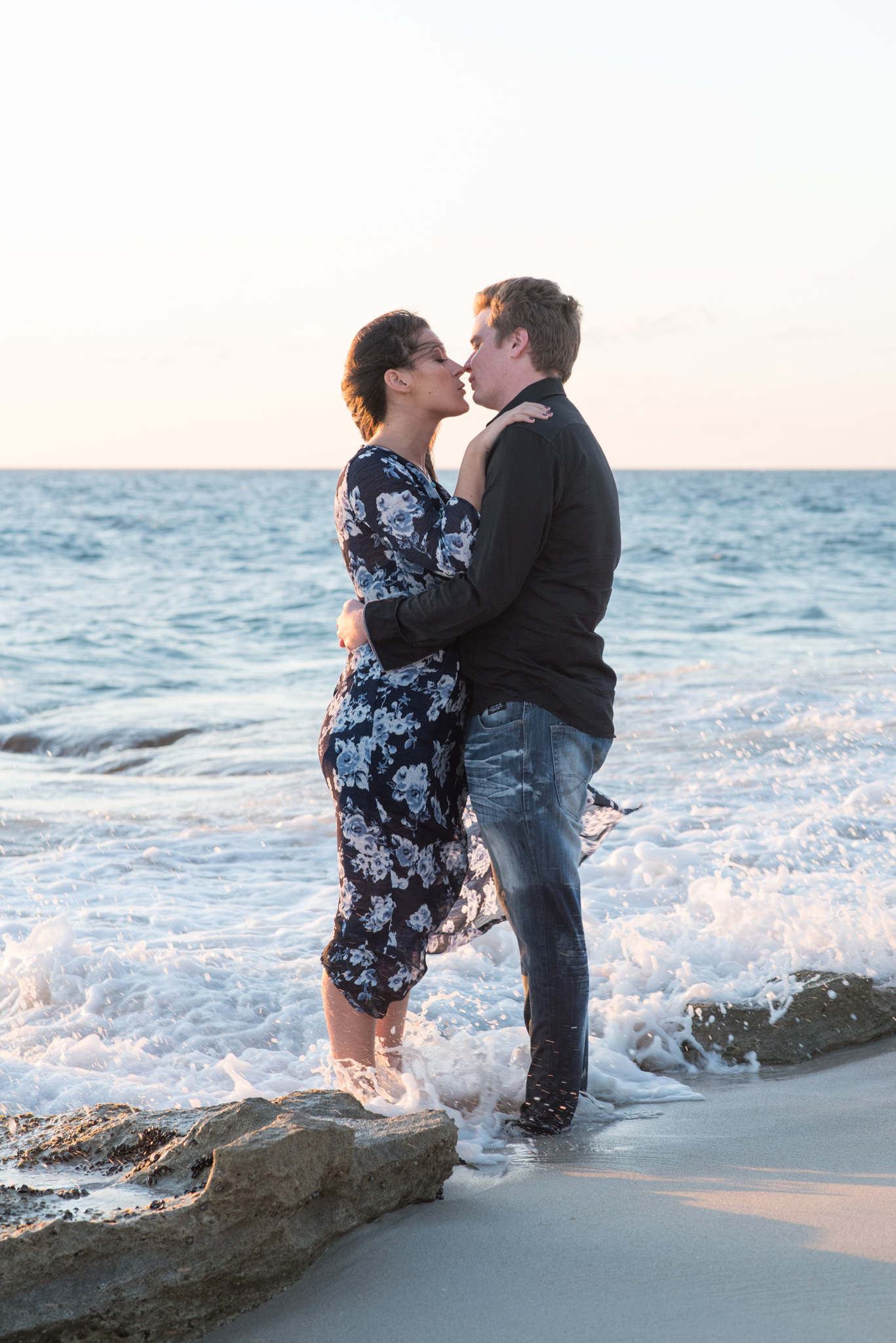 Boy and girl almost kissing in waves at Burns beach