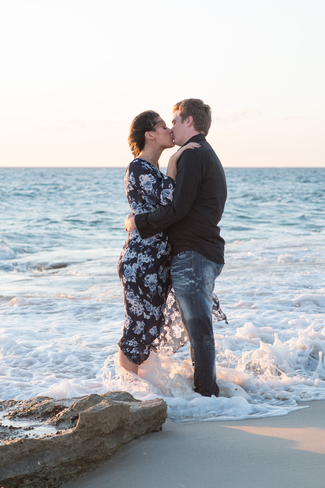 Boy and girl kissing at Burns beach