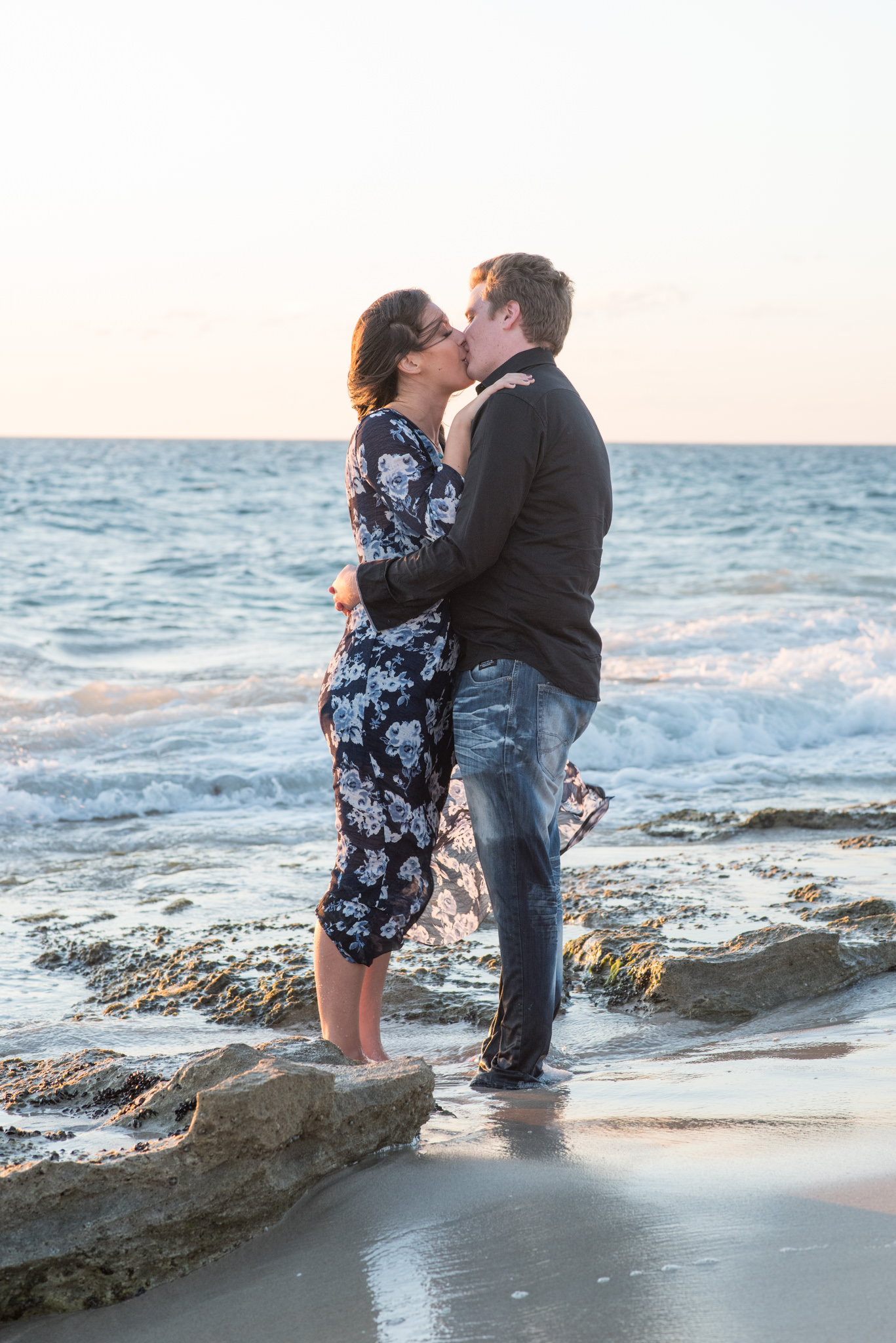 Boy and girl kissing on shallows at Burns beach