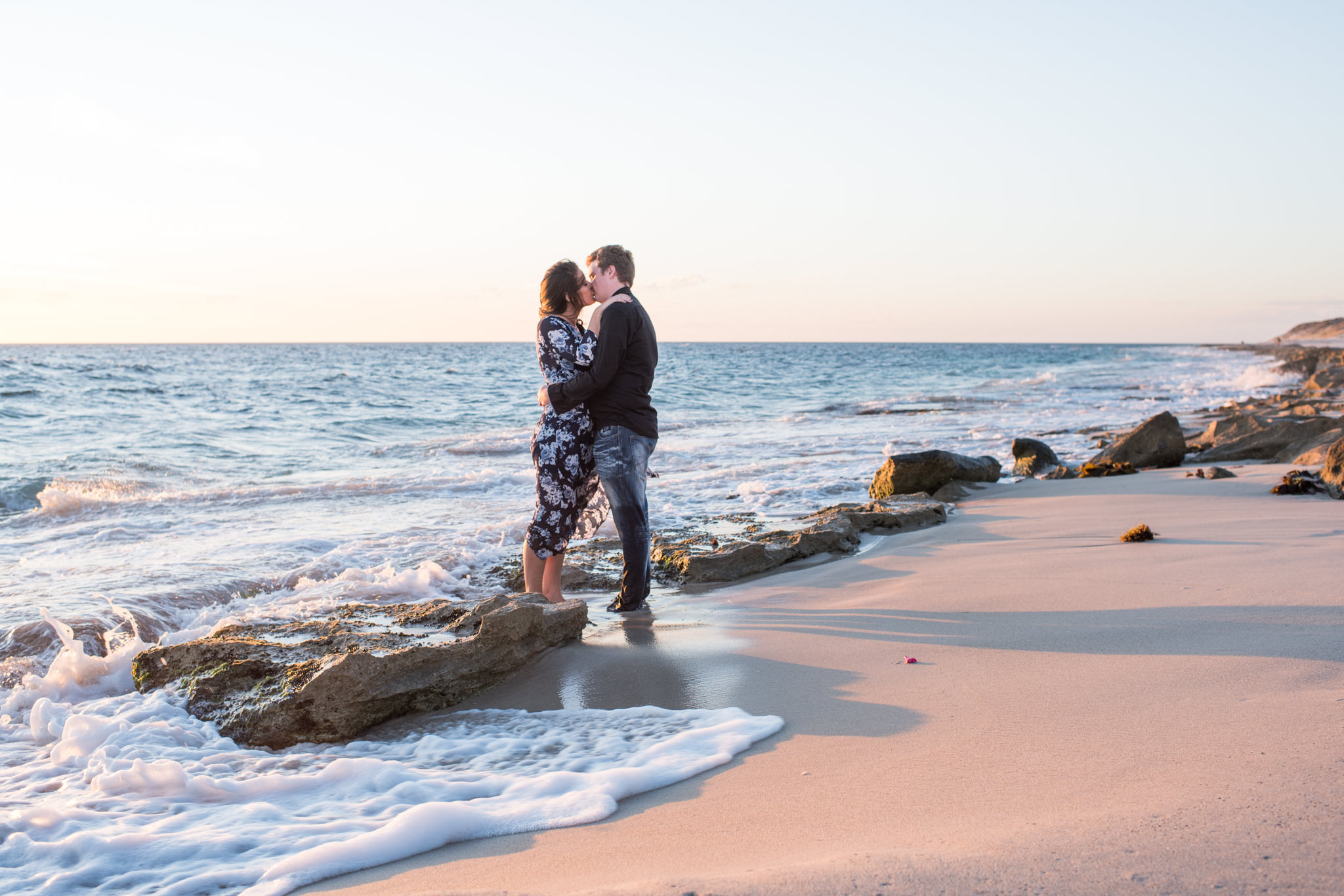 Boy and girl kissing on Burns beach