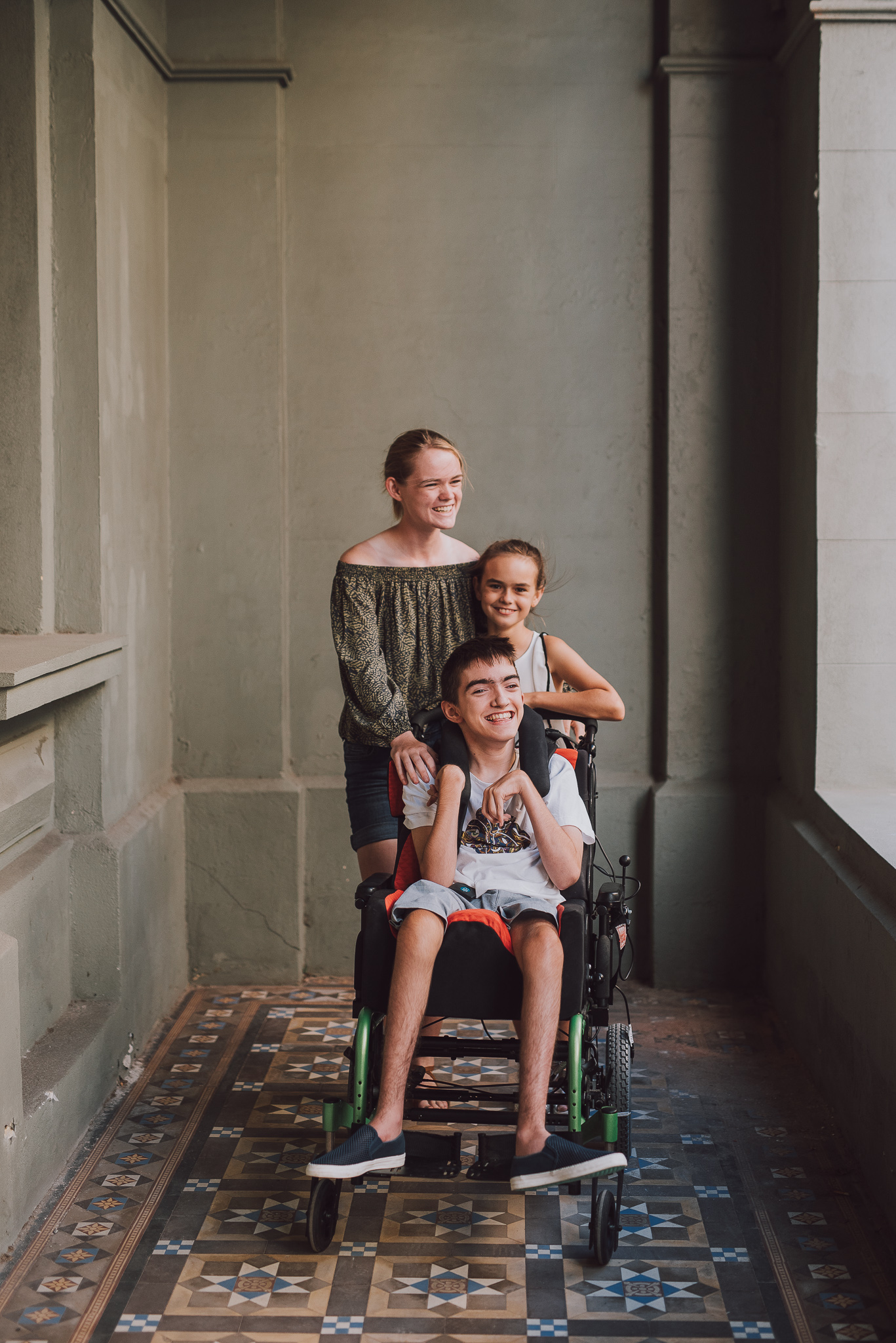 two sisters and their brother in wheelchair having portrait taken in Fremantle