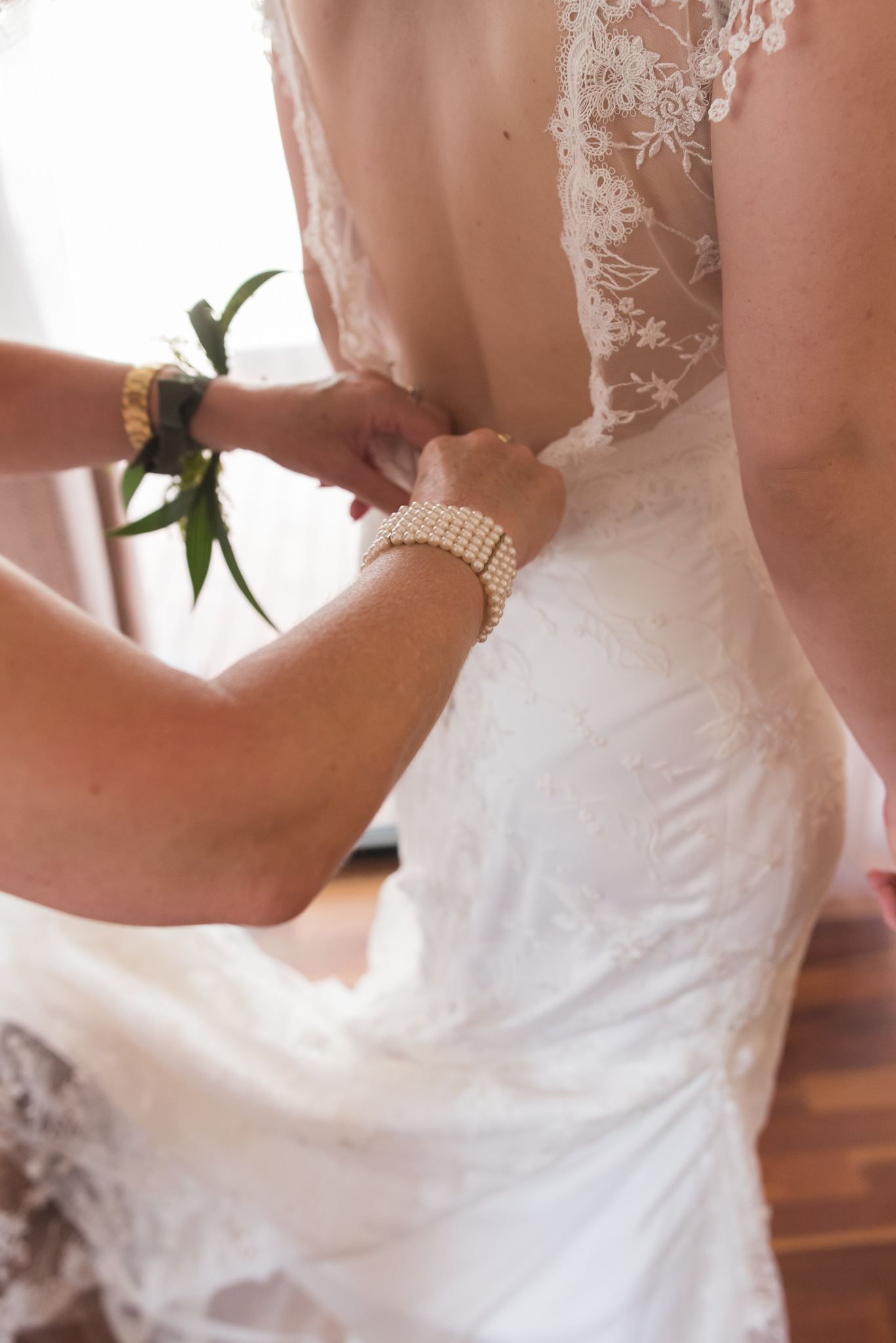 Bride's mother does up the wedding dress