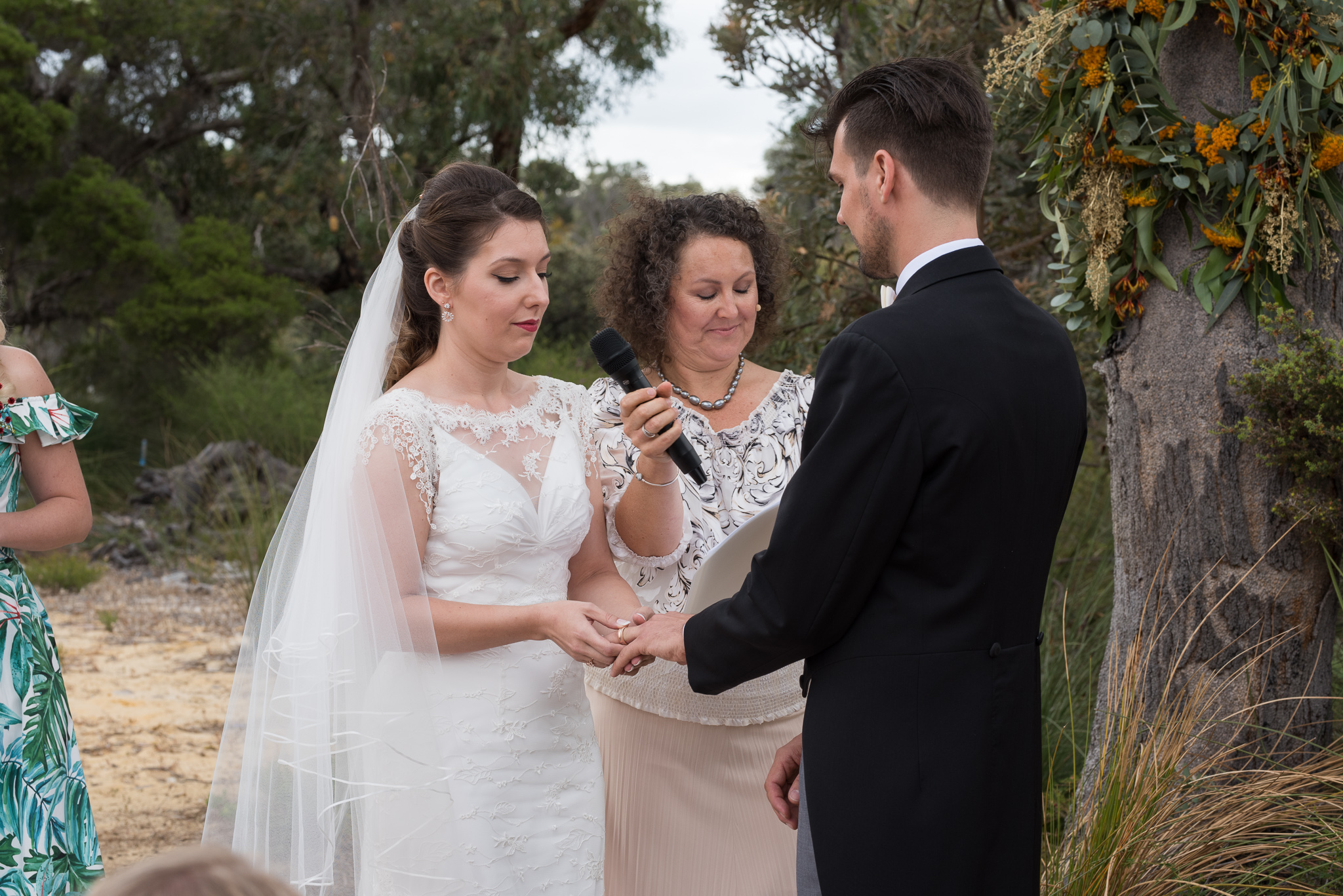 Bride places ring on grooms finger at the GDC