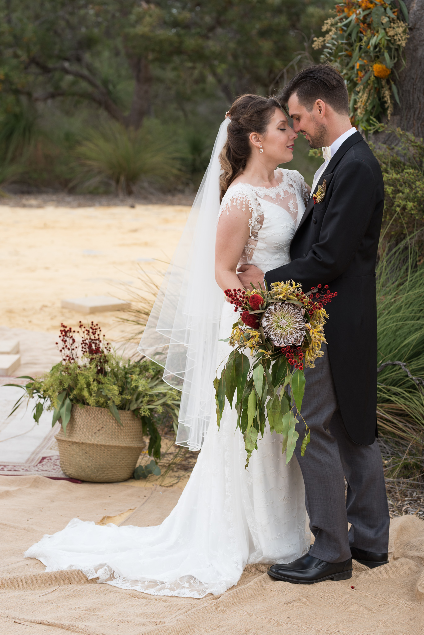 Bride and groom holding each other in the bush