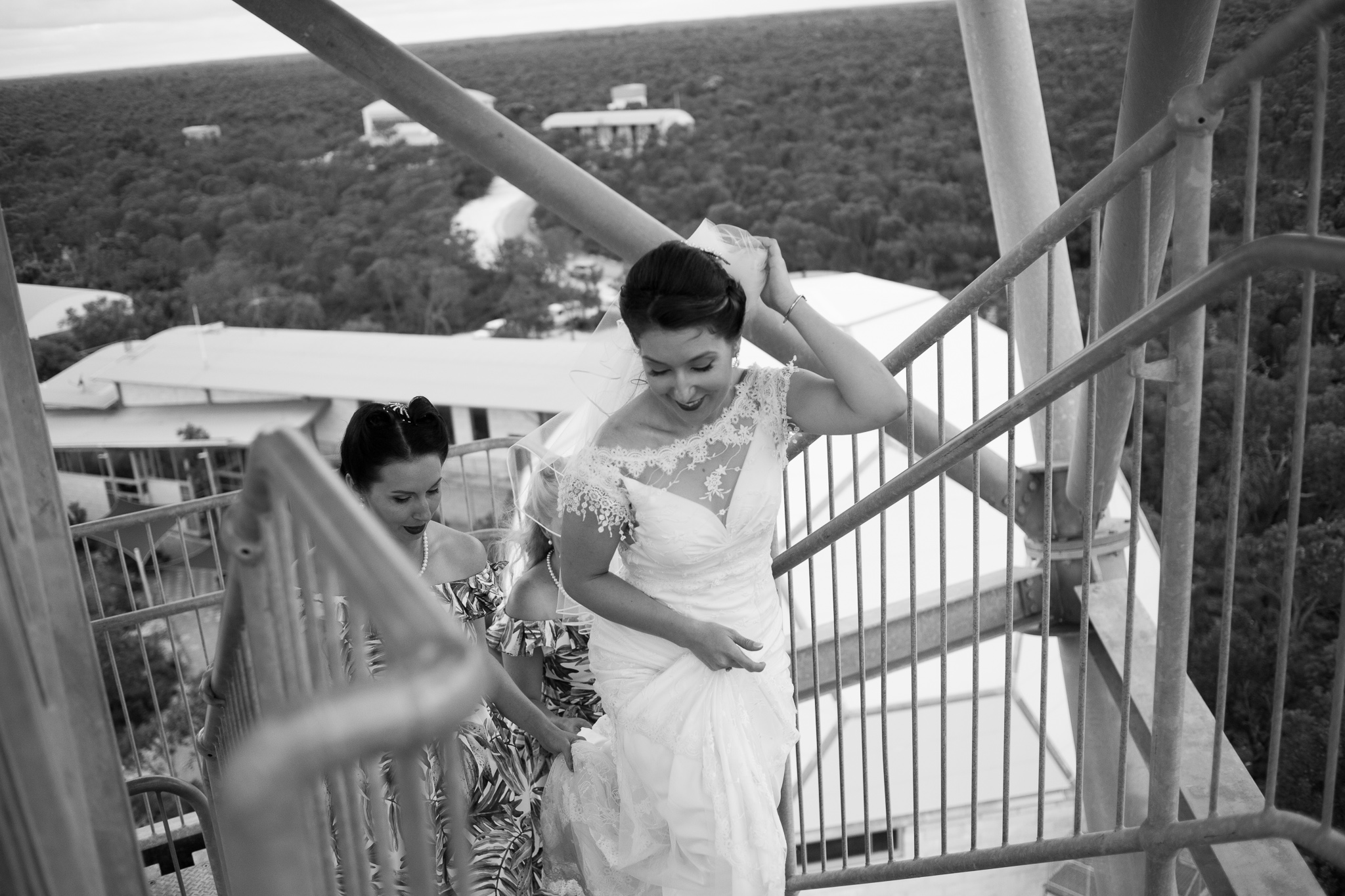 Bride and bridesmaids walking up the leaning gravity tower