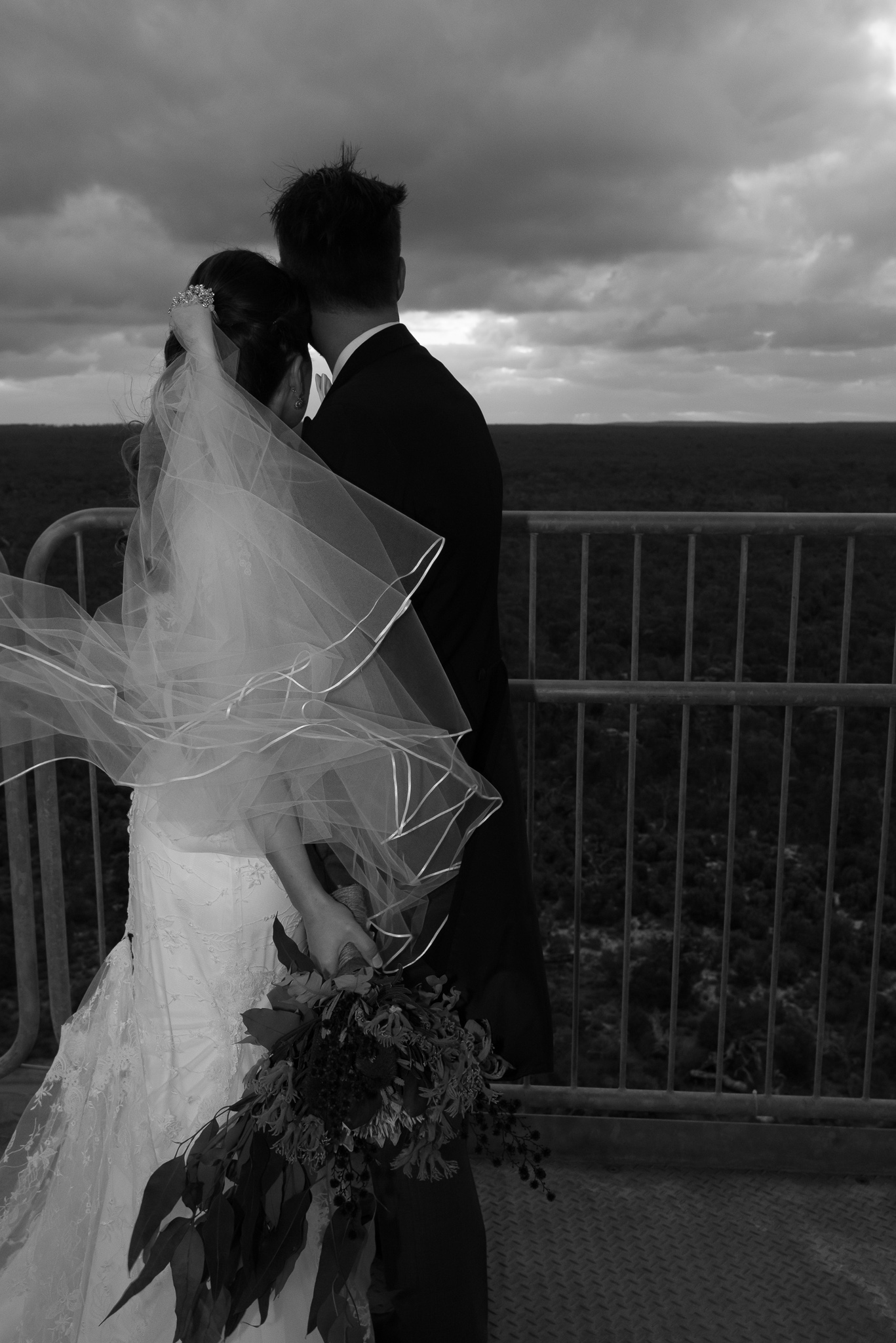 Wedding couple looking at the view of the leaning gravity tower